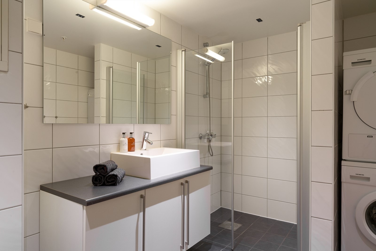 Badet ved stuen er også lekkert, helfliset og har vannbåren gulvvarme. Galleribilde