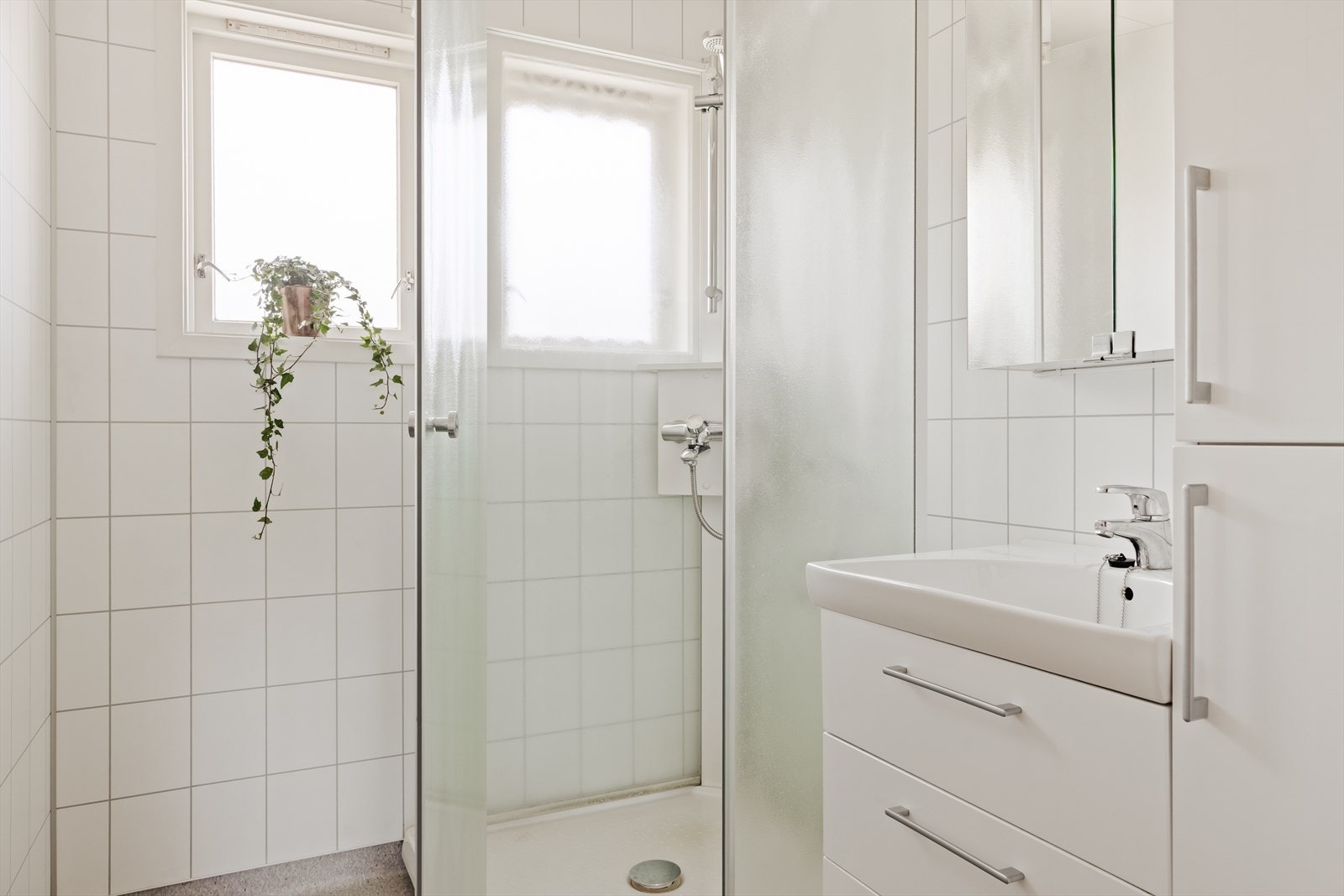- Badet måler 3,2 m² og er utstyrt med dusjkabinett, servant med møblement, høyskap og speilskap - Galleribilde