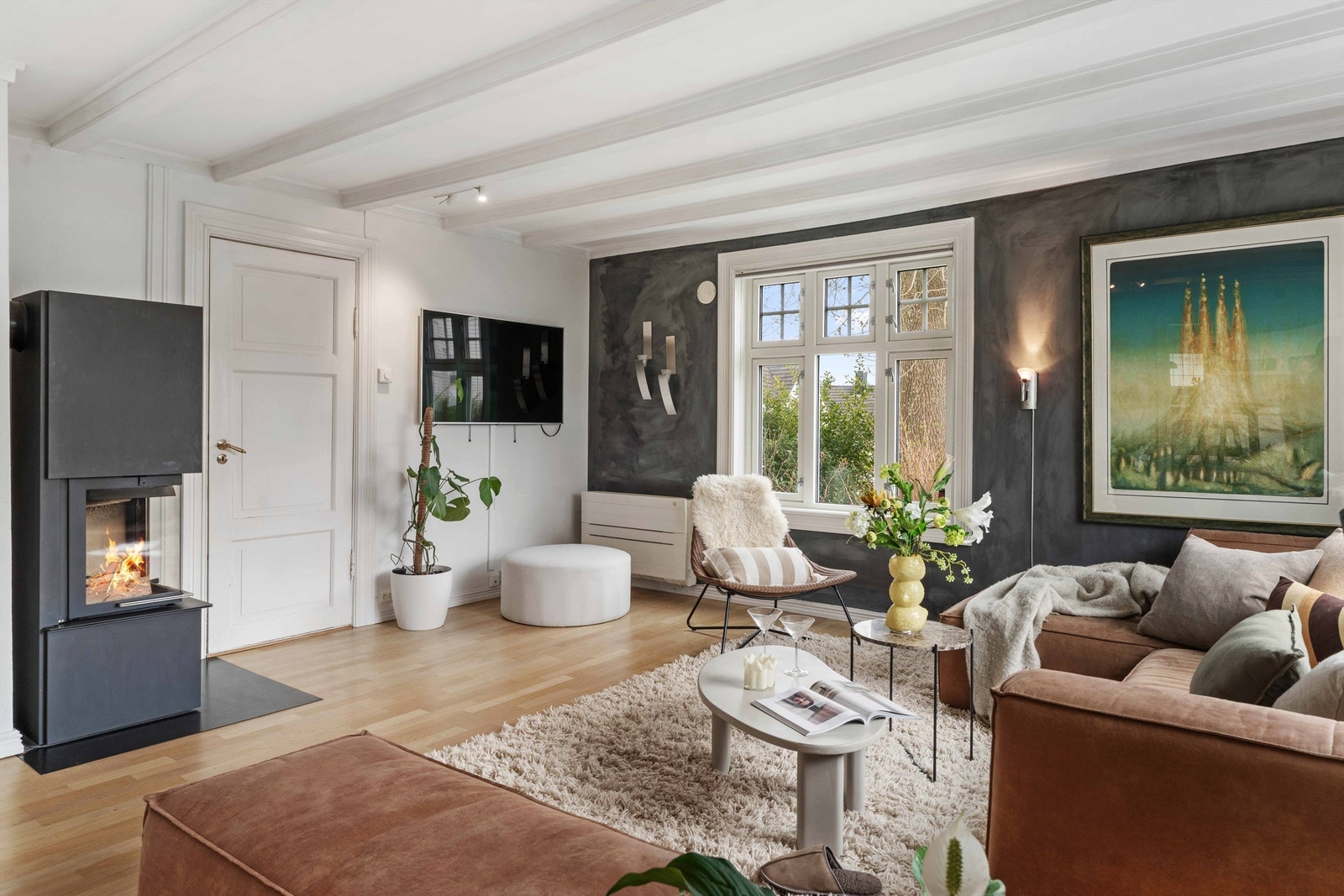 Stuen er utstyrt med både en peisovn med glassdør og en effektiv varmepumpe, som gir fleksible oppvarmingsmuligheter. Galleribilde