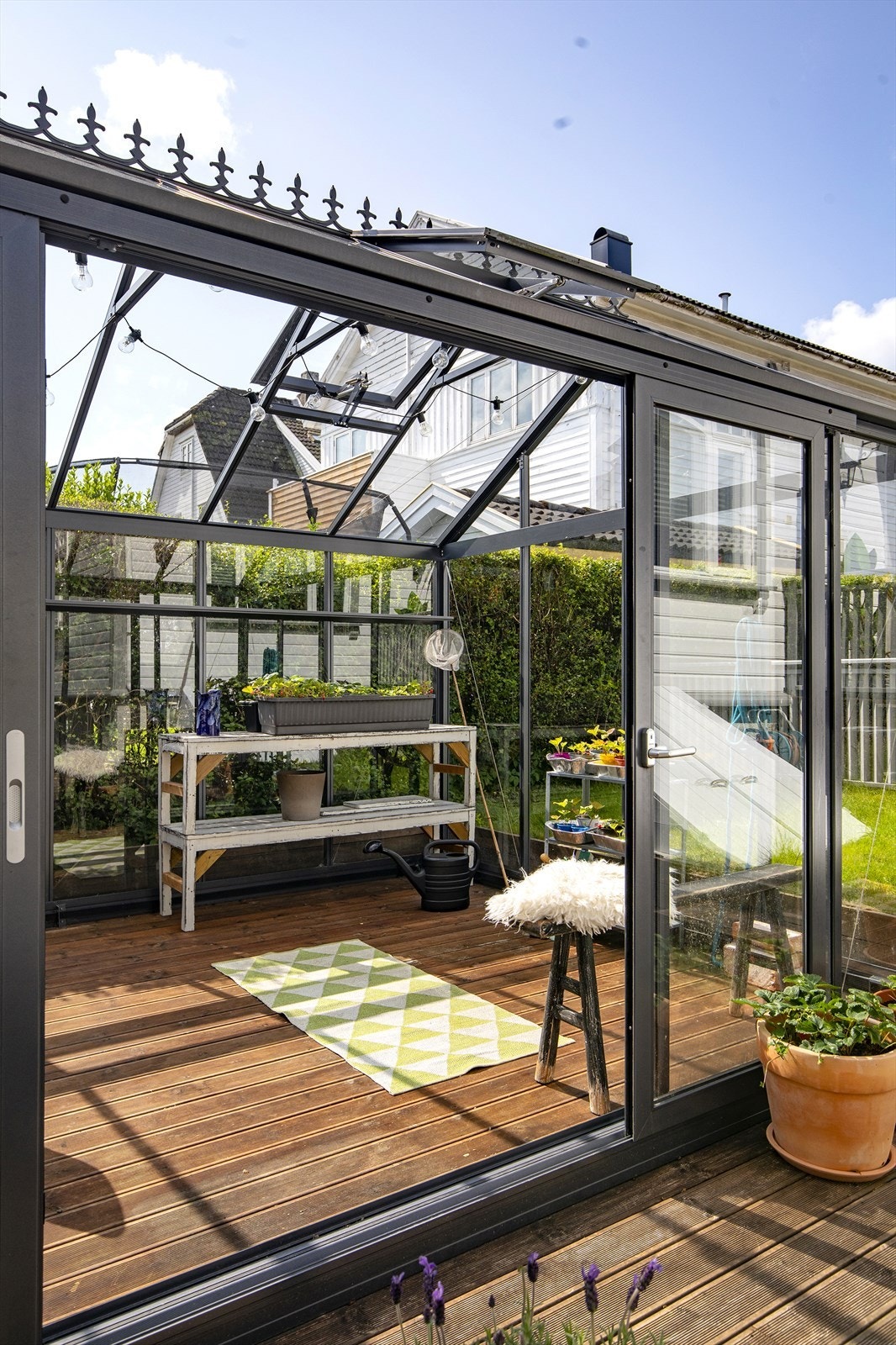 Inne i drivhuset er det god plass til både planter og en liten sittegruppe. Galleribilde