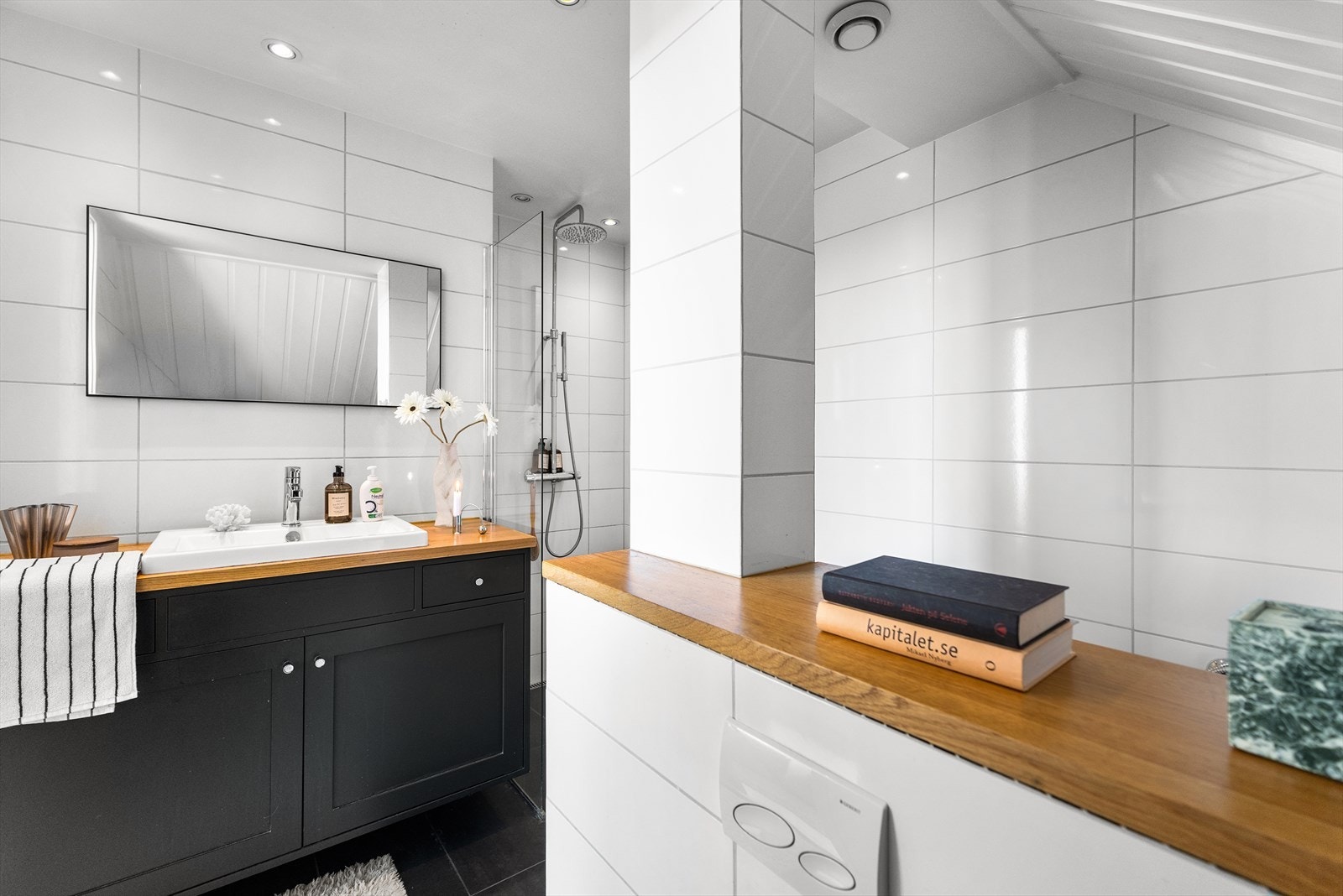 Helfliset bad med varmekabler i gulv og downlights i himling. Baderomsinnredning med benkeplate av heltre og nedfelt servant Galleribilde