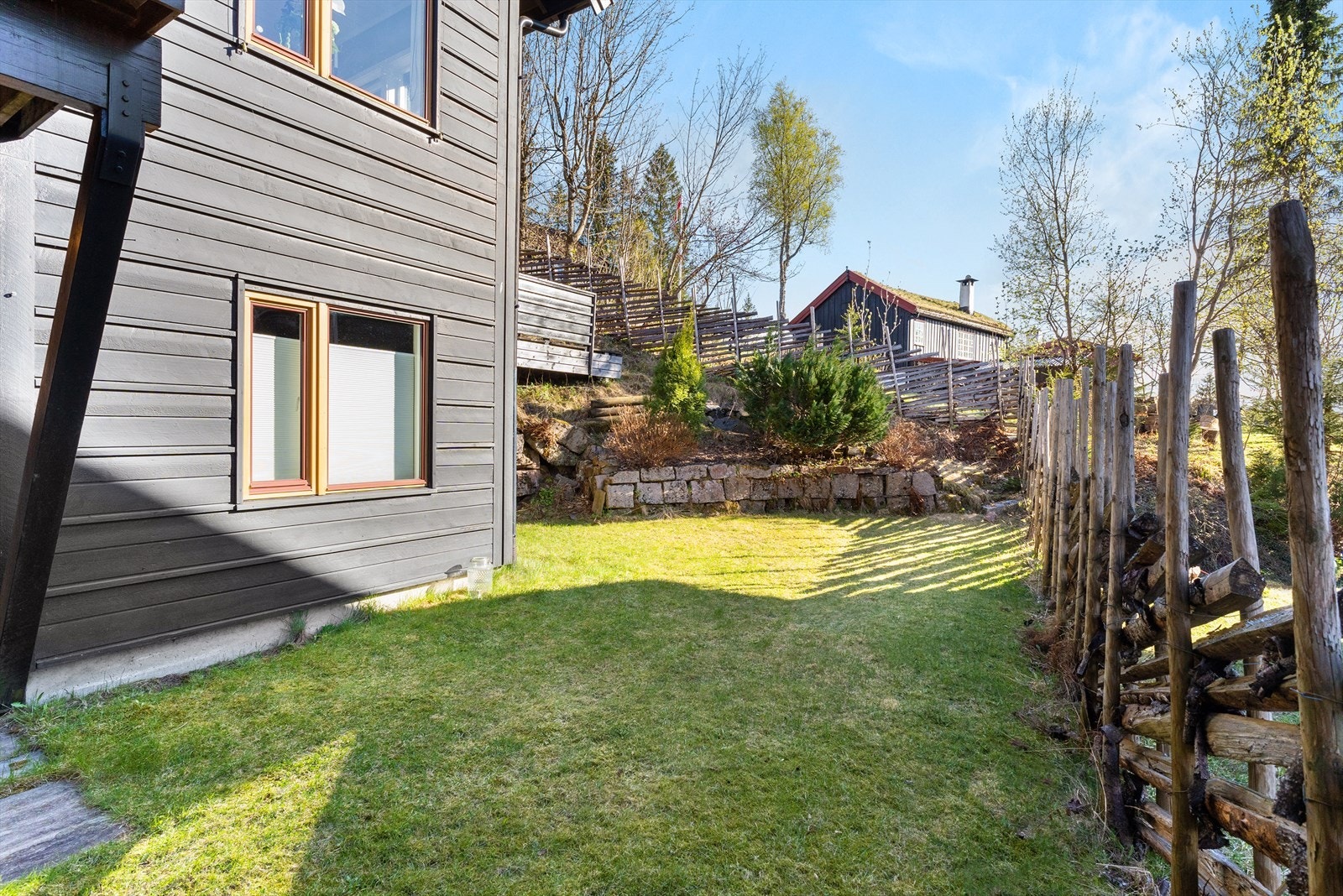 Fra gangen i 1. etasje er det utgang til hagen. Idyllisk og barnevennlig - et fantastisk sted for familien å tilbringe lange og fine sommerkvelder Galleribilde
