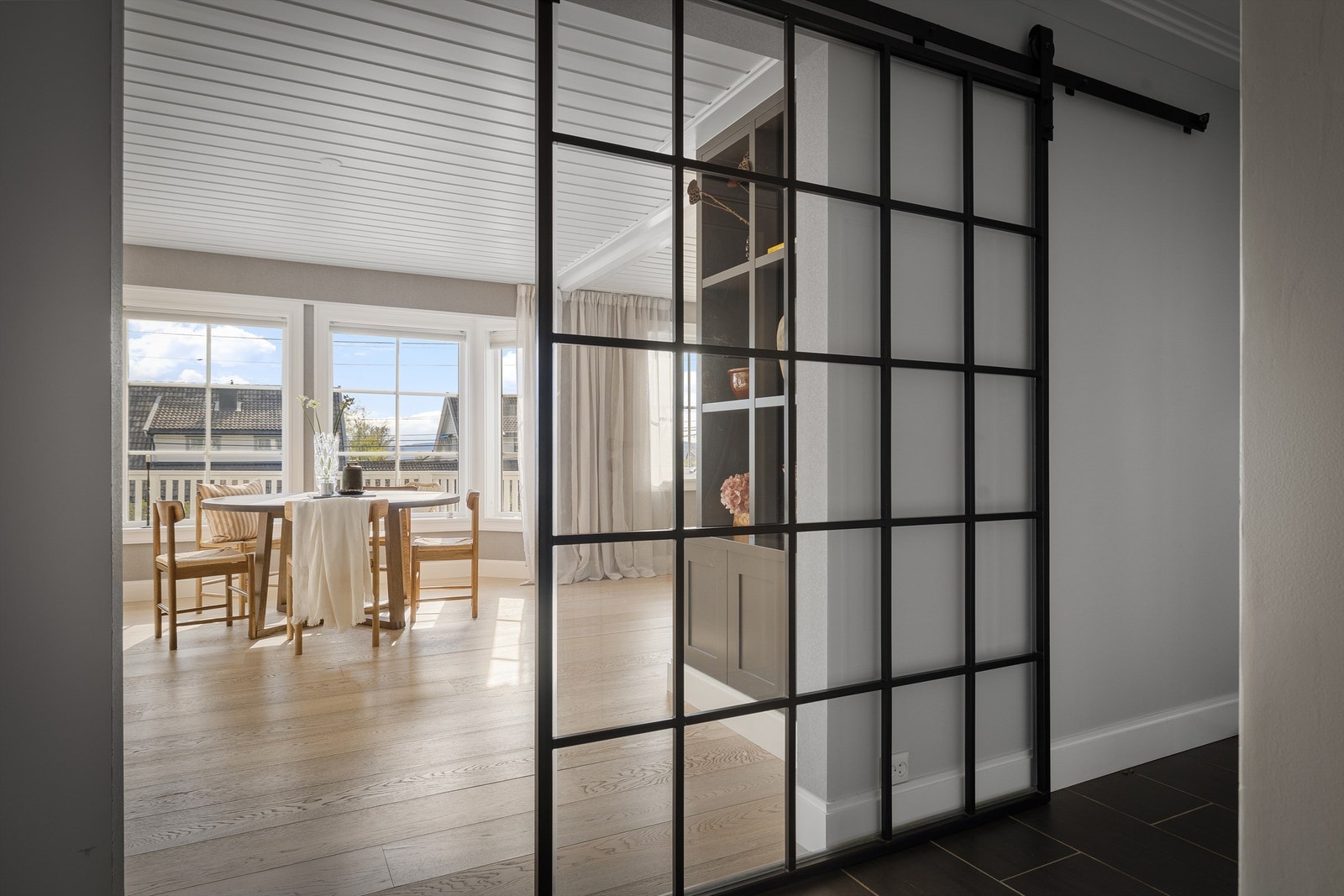 Mye lys slippes inn fra stuen gjennom en smijerns skyvedør med glass, som er produsert på mål Galleribilde