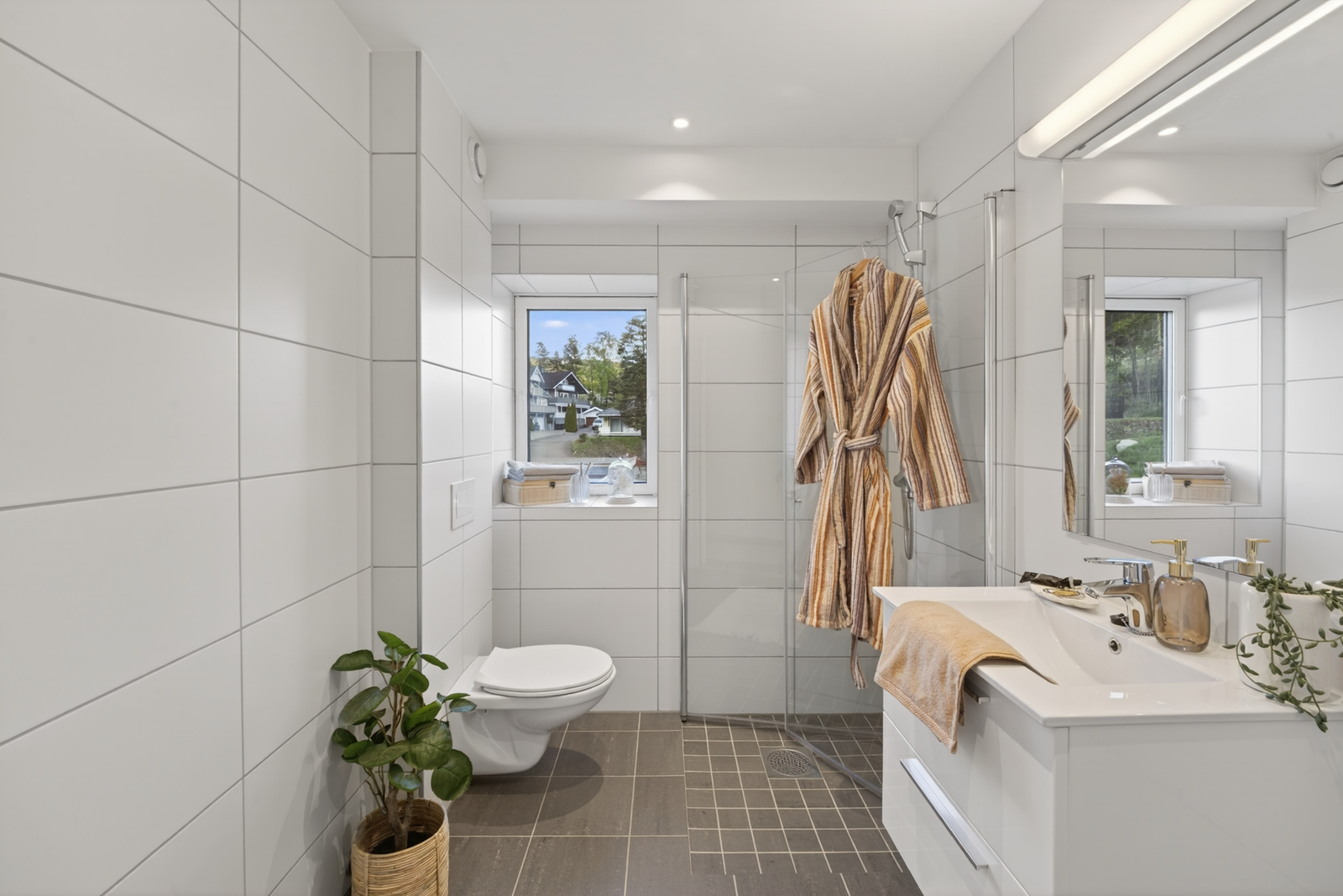 Badet preges av moderne detaljer, inkludert dusj og vegghengt toalett Galleribilde