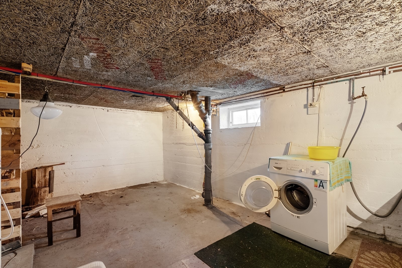 Vaskerom i kjelleren med betonggulv og sluk. Varmtvannstanken på ca. 200 liter er fra 2000. Galleribilde