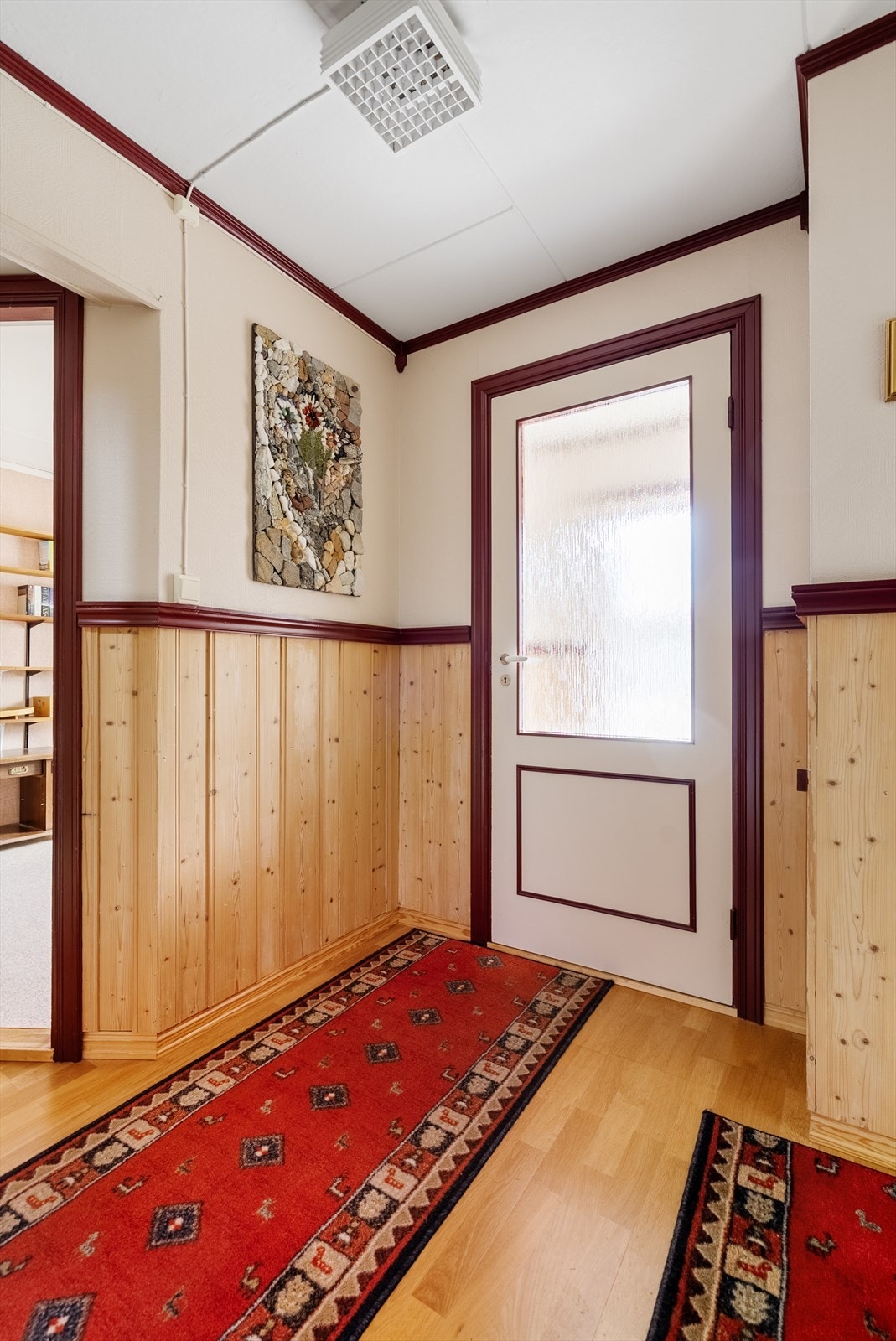 Detalj fra gangen med slette innerdører og brystningspanel i tre. Galleribilde