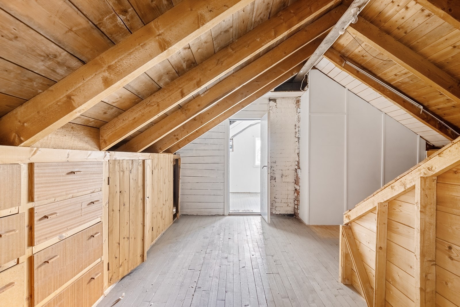 Loftet har synlige takbjelker og plassbygde oppbevaringsløsninger. Takkonstruksjonen er en sperrekonstruksjon med rupanel. Galleribilde