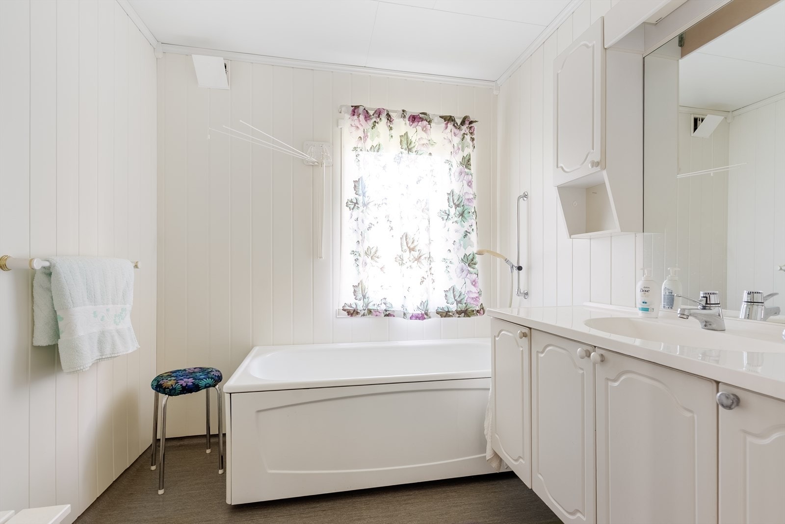 Badet i første etasje er utstyrt med badekar, servantinnredning og vinylbelegg på gulvet. Galleribilde