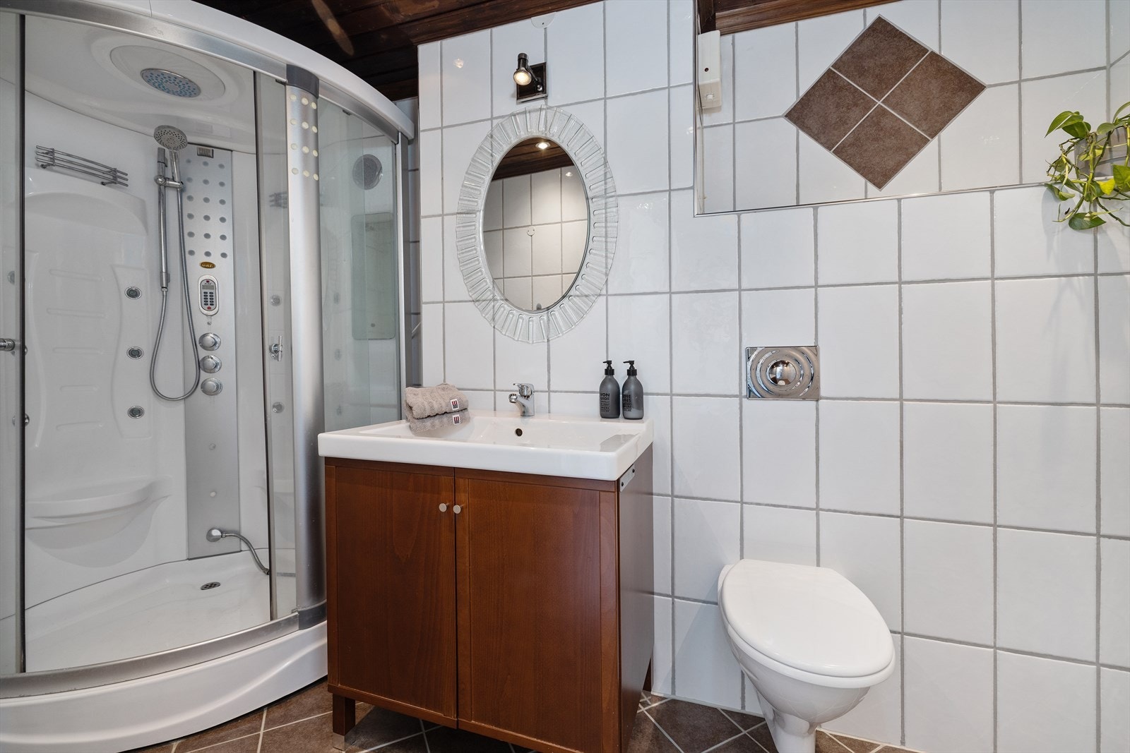 Badet er utstyrt med et dusj- og steamkabinett, vegghengt toalett og opplegg for vaskemaskin. Galleribilde