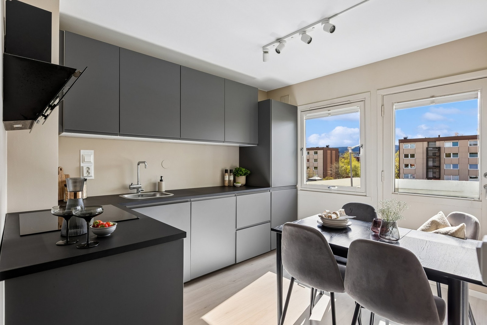 Moderne og pent kjøkken med integrerte hvitevarer bestående av stekeovn, platetopp, oppvaskmaskin og kombinert kjøle/fryseskap. Galleribilde