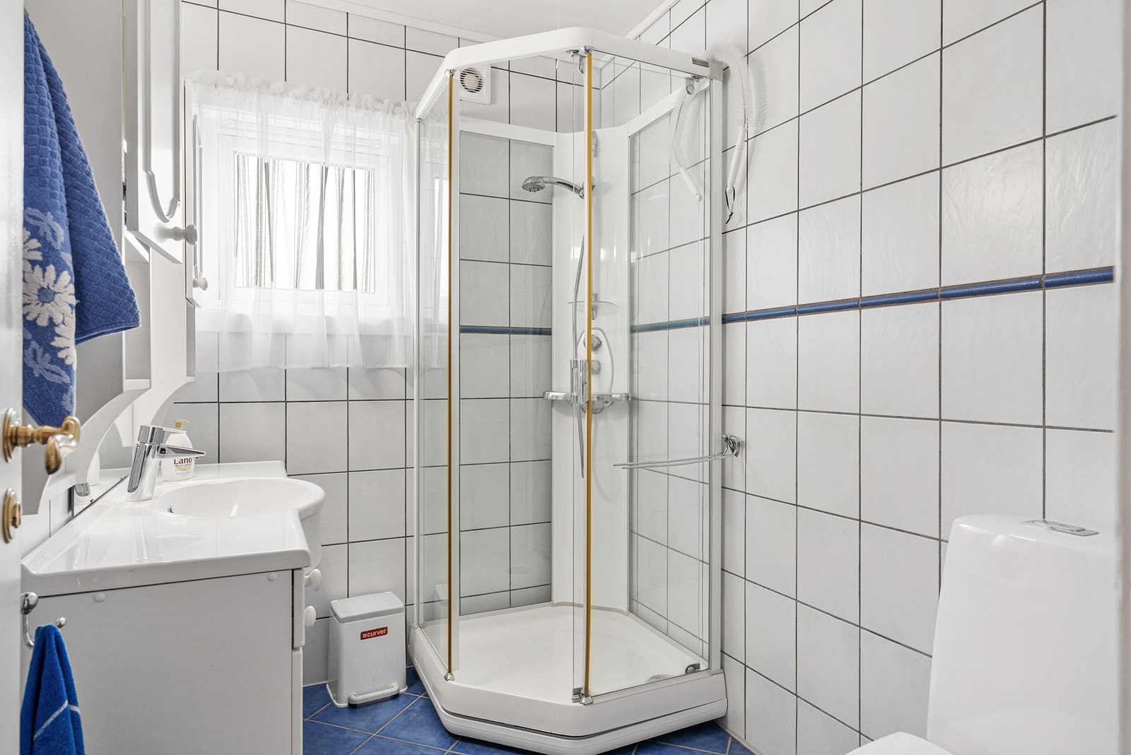Badet er praktisk innredet med toalett, dusjkabinett og baderomsinnredning med nedfelt servant Galleribilde