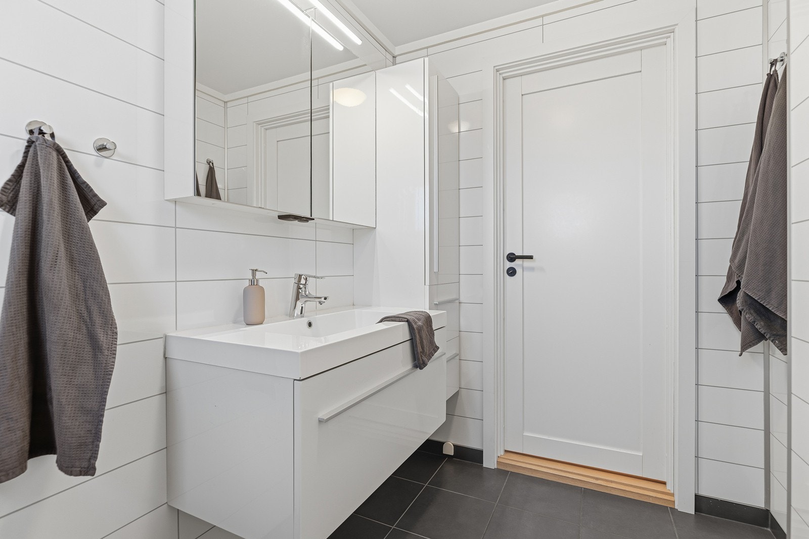 Badet er innredet med toalett, dusjkabinett, overskap m/speil og heldekkende servant i baderomsinnredning Galleribilde