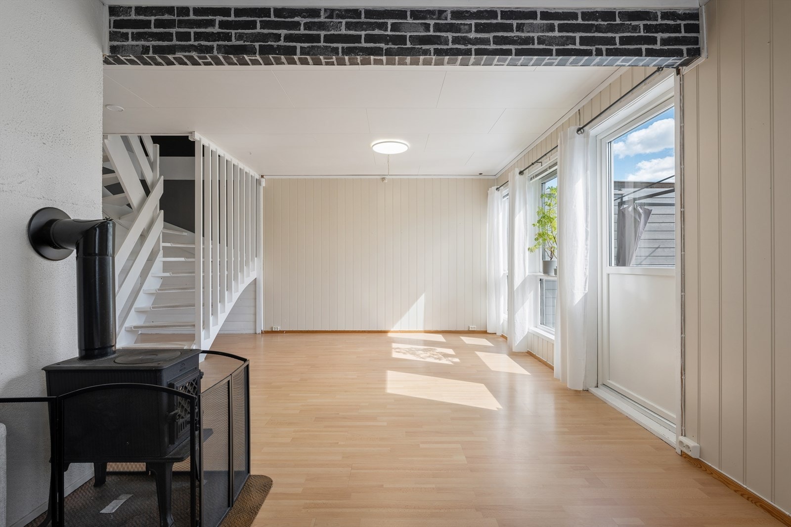 Gjennomgående lys stue med vedovn. Galleribilde