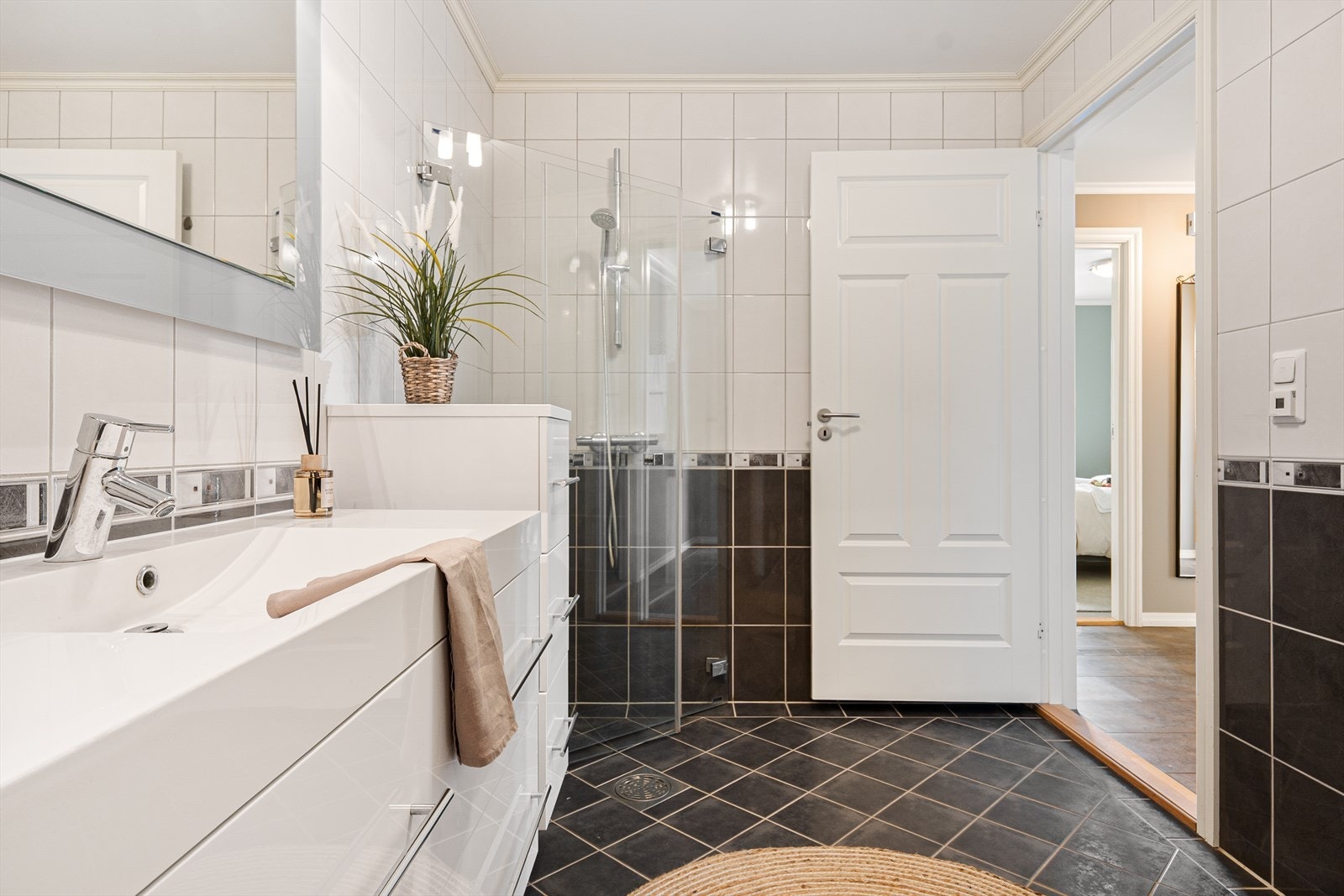 - Badet måler 6m² og er innredet med servantmøbel, speil, toalett og dusjhjørne med innfellbare glassdører - Galleribilde