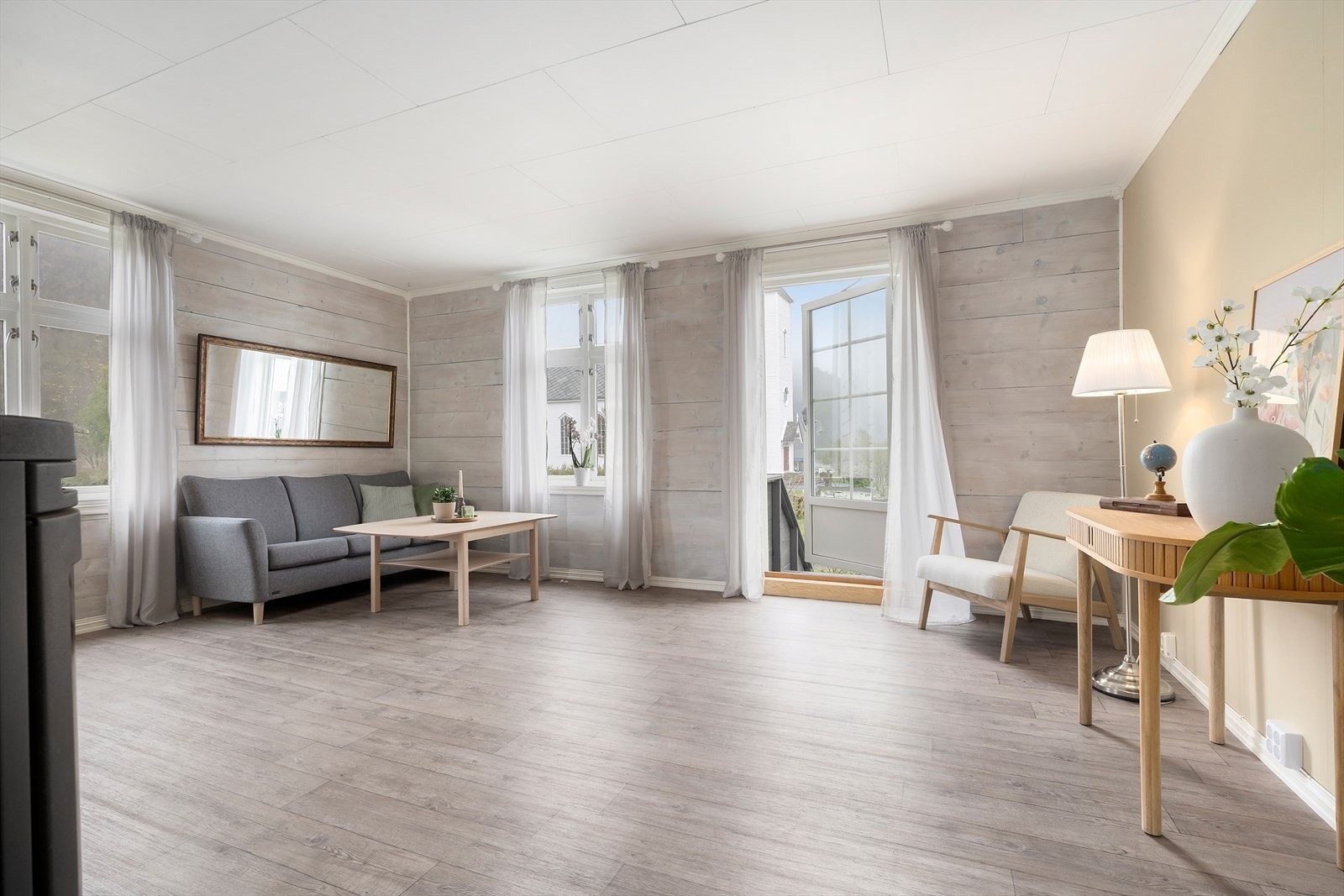Frå stova er det tikomst til stor betongplatting og hage Galleribilde
