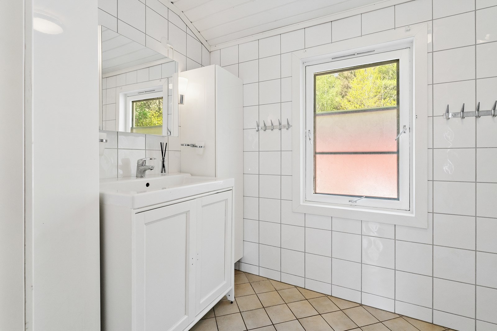 Badet har dusjkabinett fra 2020, vegghengt toalett, servant med skap, speil og veggskap. Galleribilde