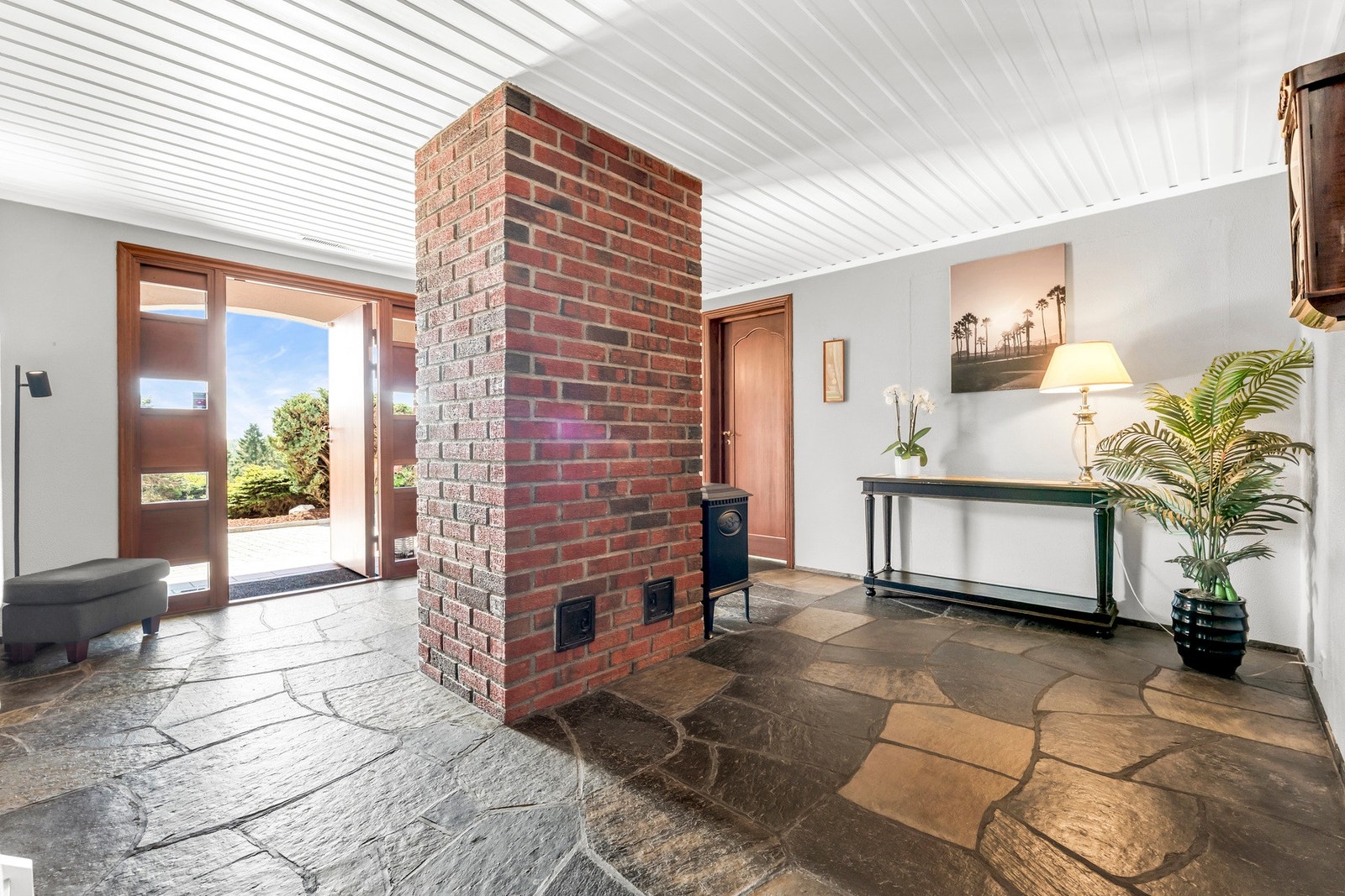 Stor entré med skifer på gulv og peisovn Galleribilde
