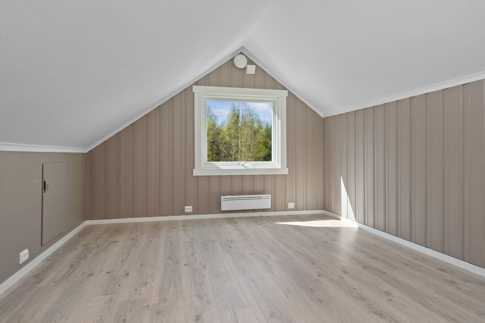 Lyst rom med vindu mot hagen. Galleribilde