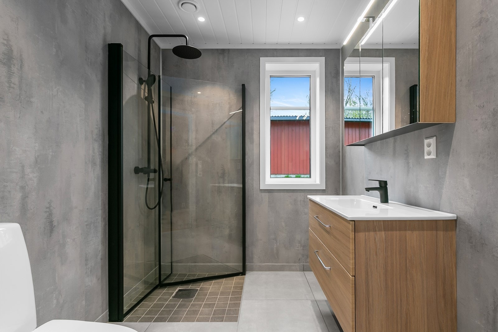 Badet har flislagt gulv, våtromsplater på vegger og mdf-himling med innfelt spotbelysning Galleribilde