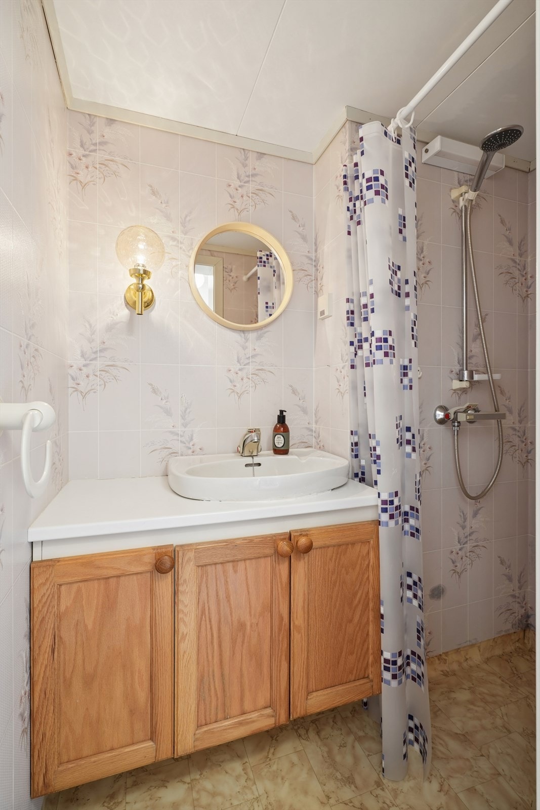 Badet i underetasjen har vinylbelegg på gulv, våtromstapet på vegger og dusjnisje. Galleribilde