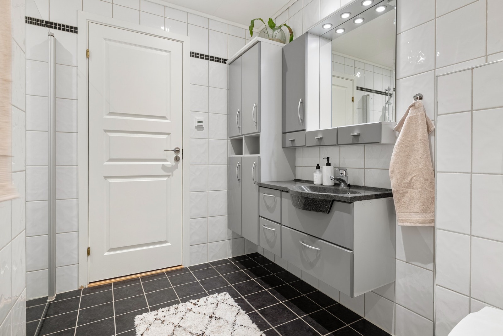 Badet er innredet med servant, veggmontert
toalett, badekar og dusjvegger/hjørne. Galleribilde