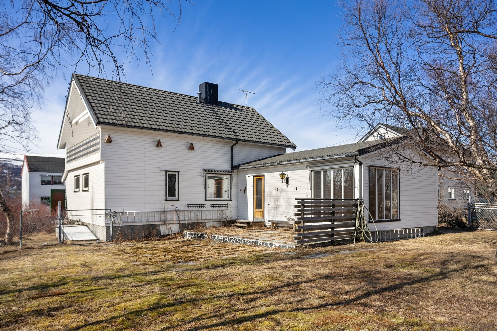 Baksiden av huset viser et tilbygg med store vinduer. Galleribilde