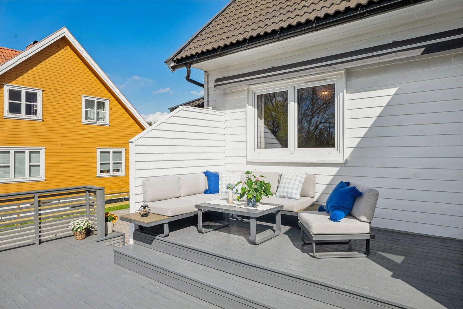 Terrassen strekker seg langs husveggen og gir flere soner for utemøbler. Galleribilde