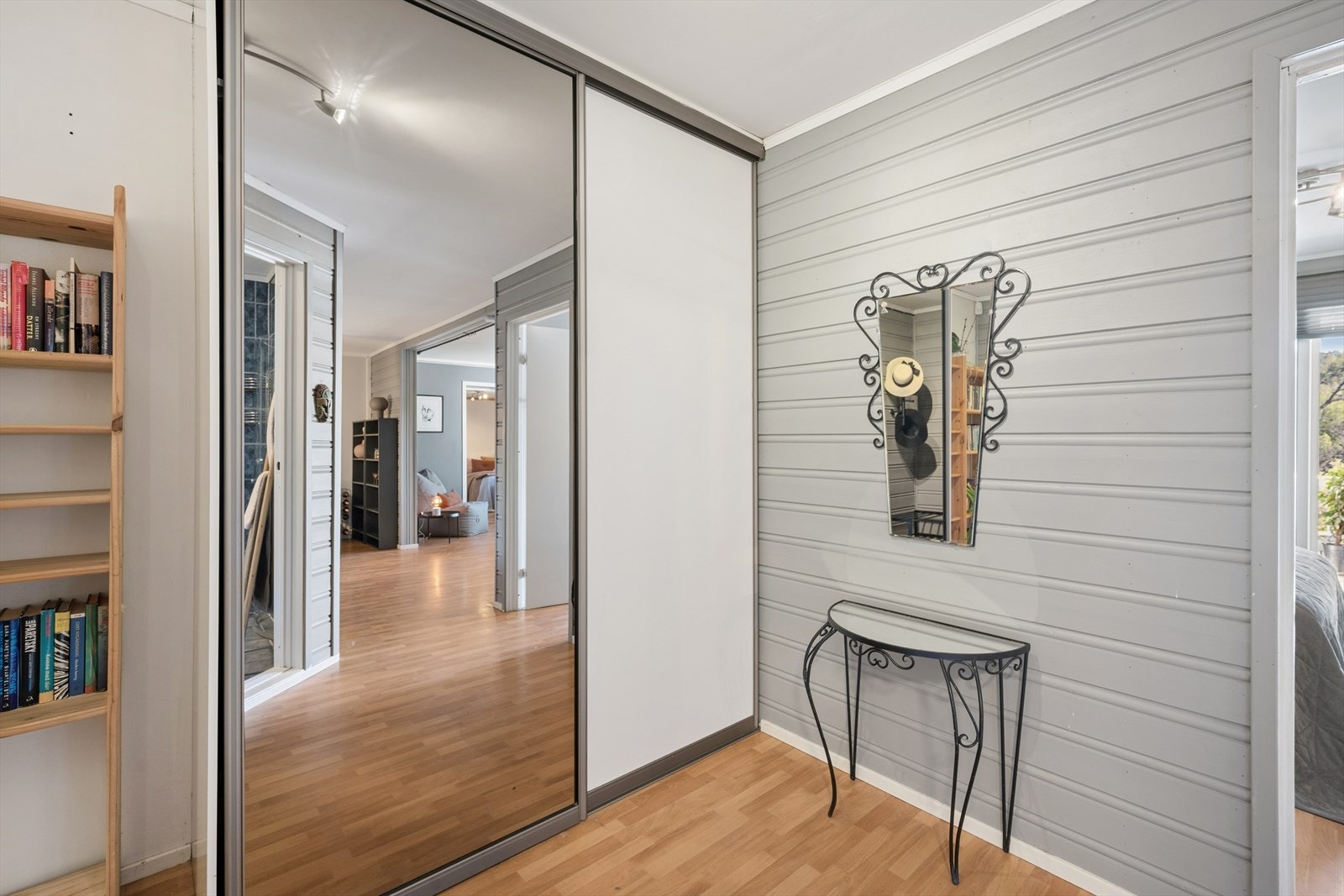 Entréen fremstår lys og innbydende med gode oppbevaringsmuligheter. Her er det skyvedørsgarderobe med speilfronter som gir rikelig med plass til yttertøy og sko, samtidig som speilene bidrar til en romslig følelse. Galleribilde