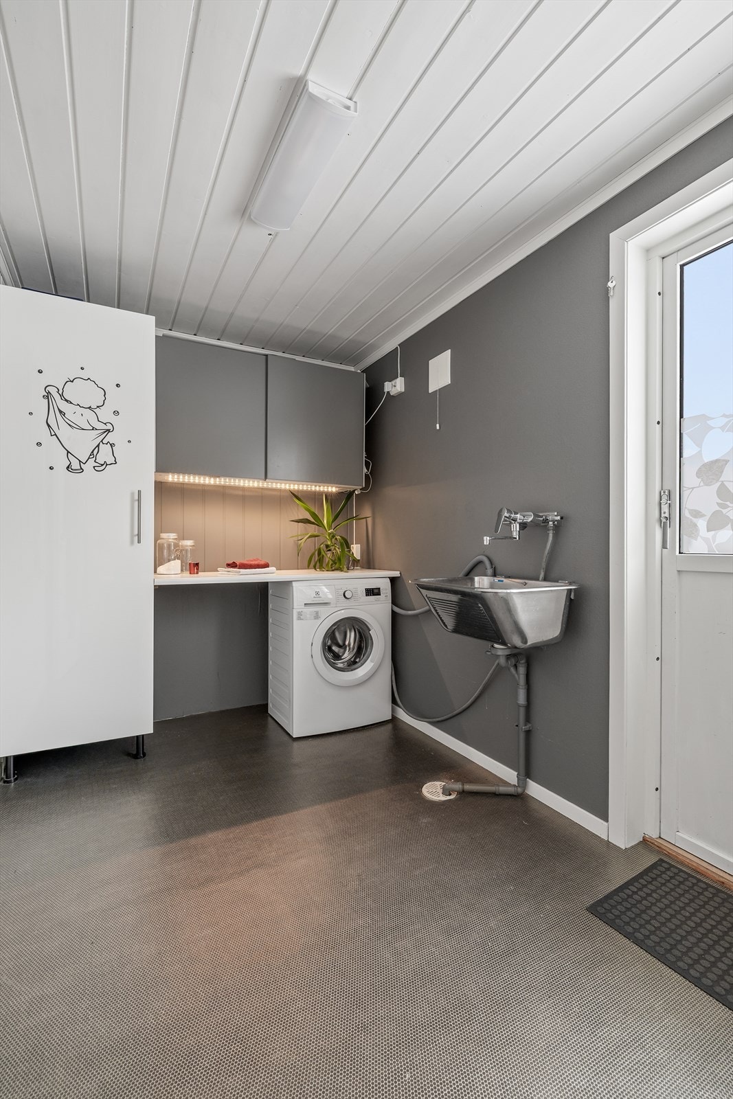 Praktisk vaskerom med egen utgang. Gulvet har vinylbelegg med varmekabler. Galleribilde