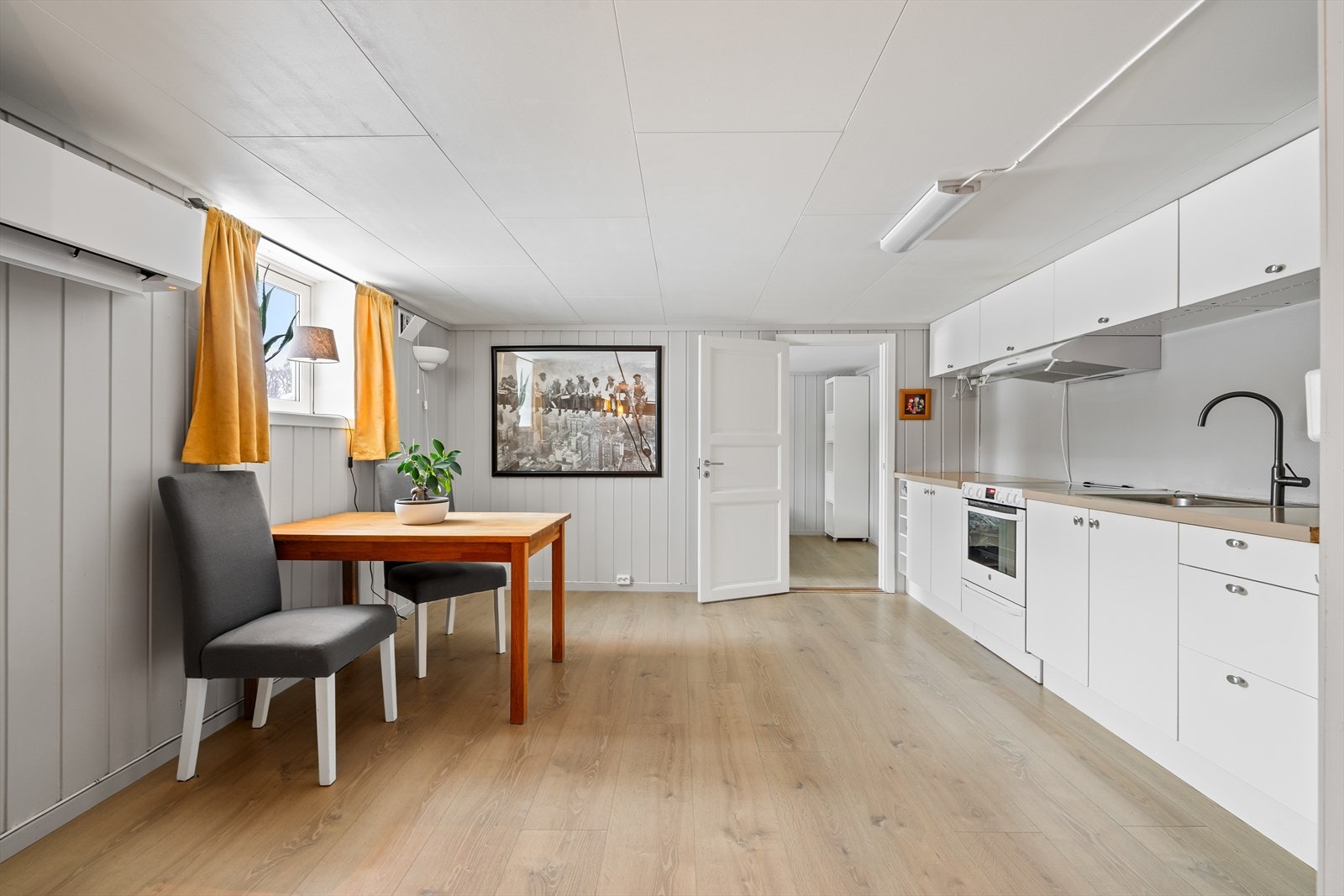Kjøkkenkroken har innredning med glatte fronter, laminatbenkeplate og ventilator med kullfilter. Galleribilde