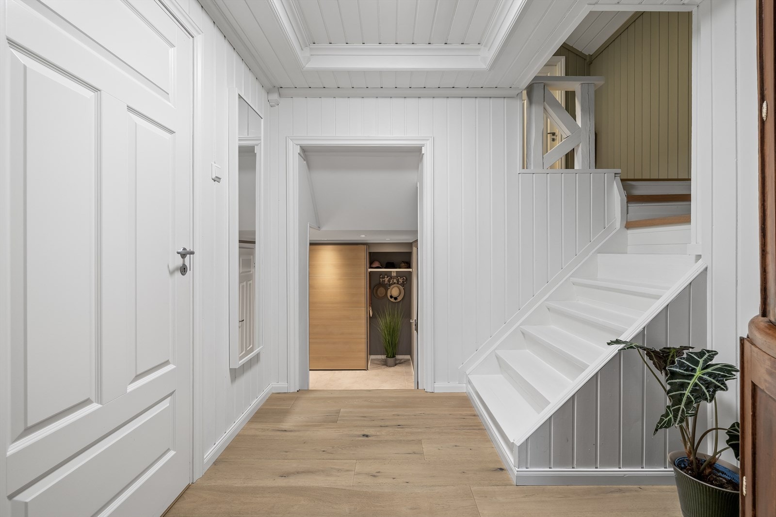 Gangen binder sammen entreen med stuen og har en malt tretrapp til andre etasje. Galleribilde