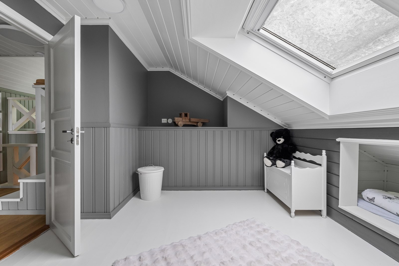 Rommet er lyst med takvindu og panel på vegger og i tak. Galleribilde