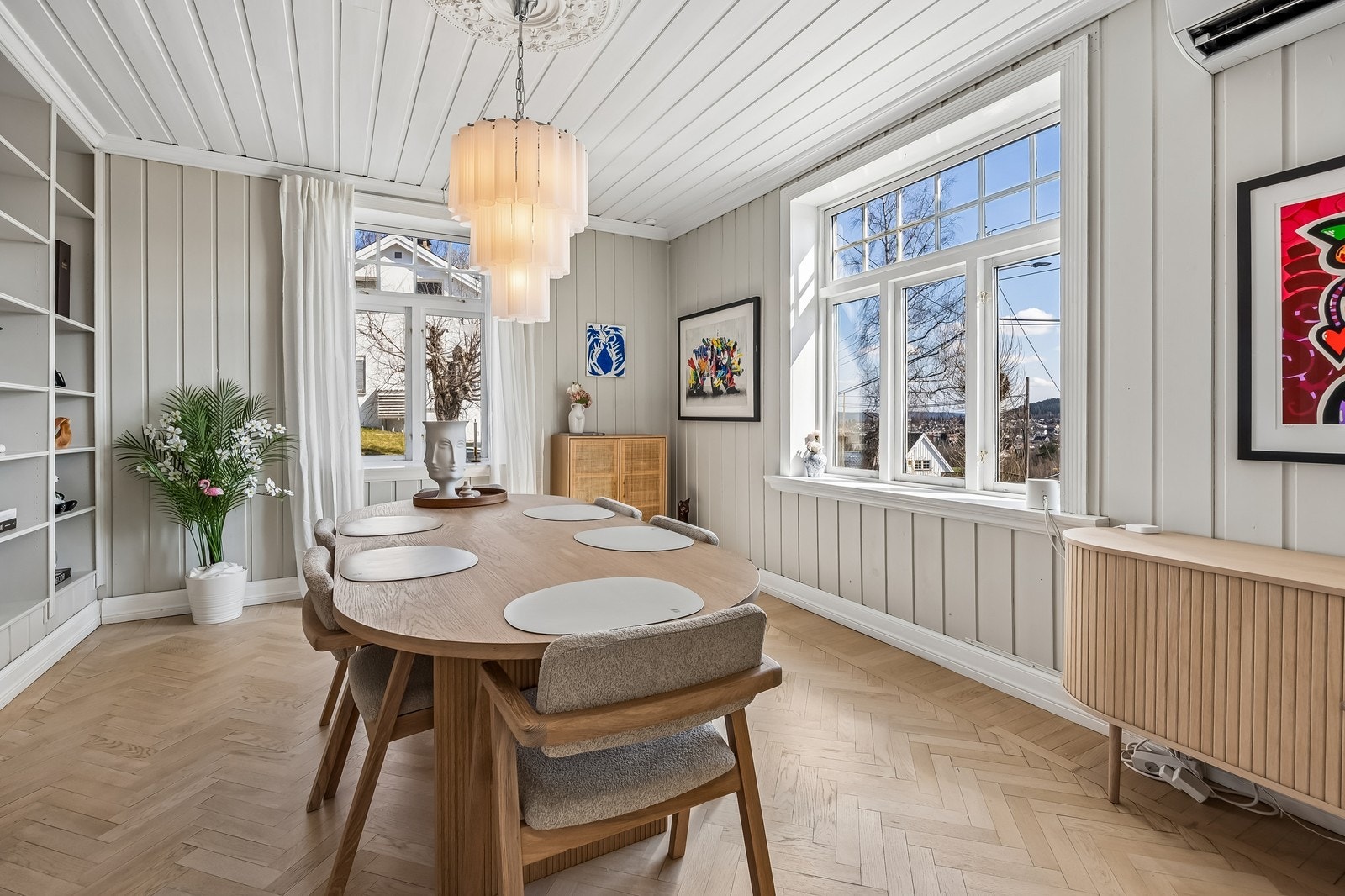Spisestuen har stor vinduer som gir mye naturlig lys og en behagelig atmosfære Galleribilde
