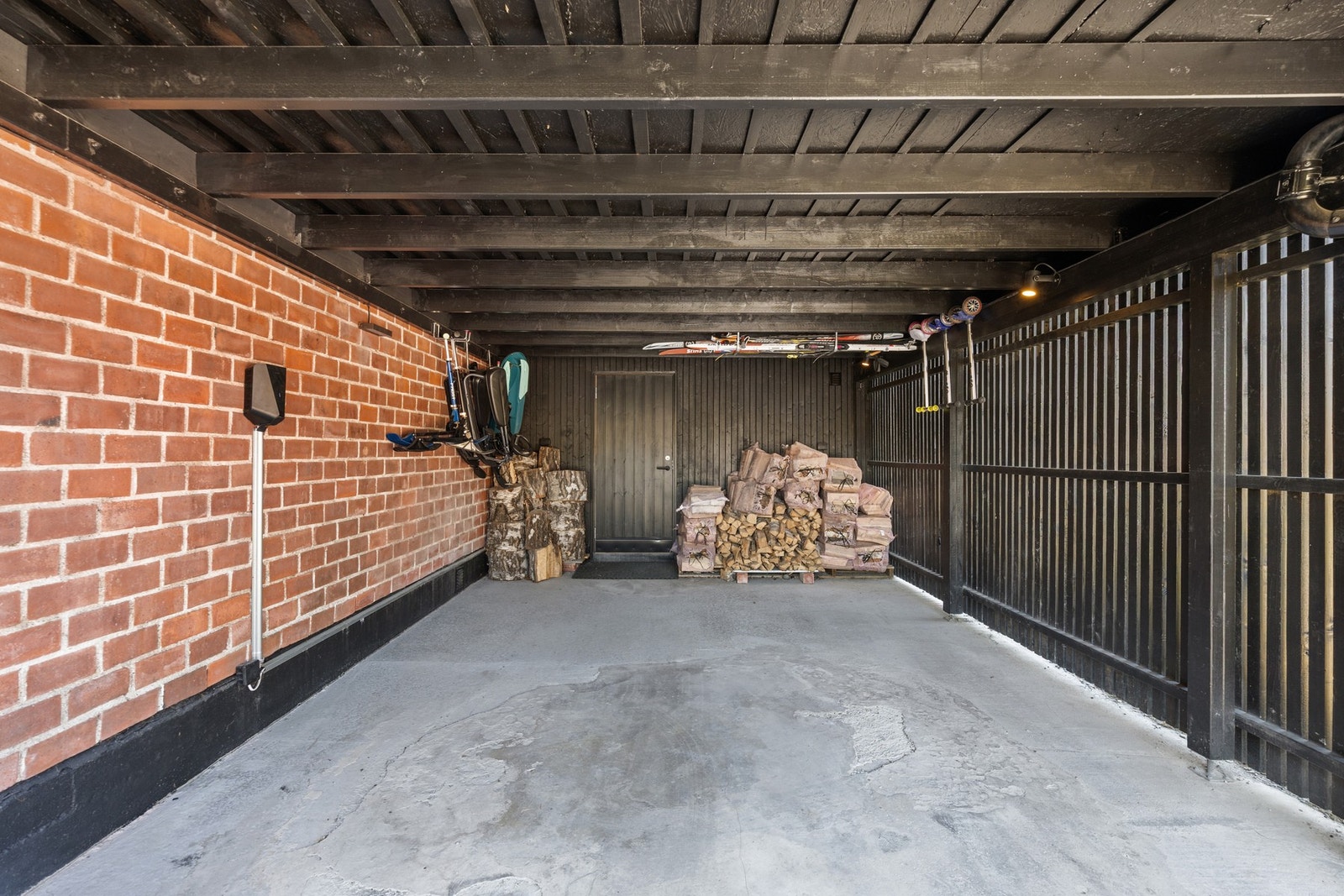 Det er parkering for en bil i carport. Her er det også lader for elbil. Innenfor carporten er det en praktisk bod. I tillegg er det ytterligere en utebod på andre siden av boligen. Galleribilde