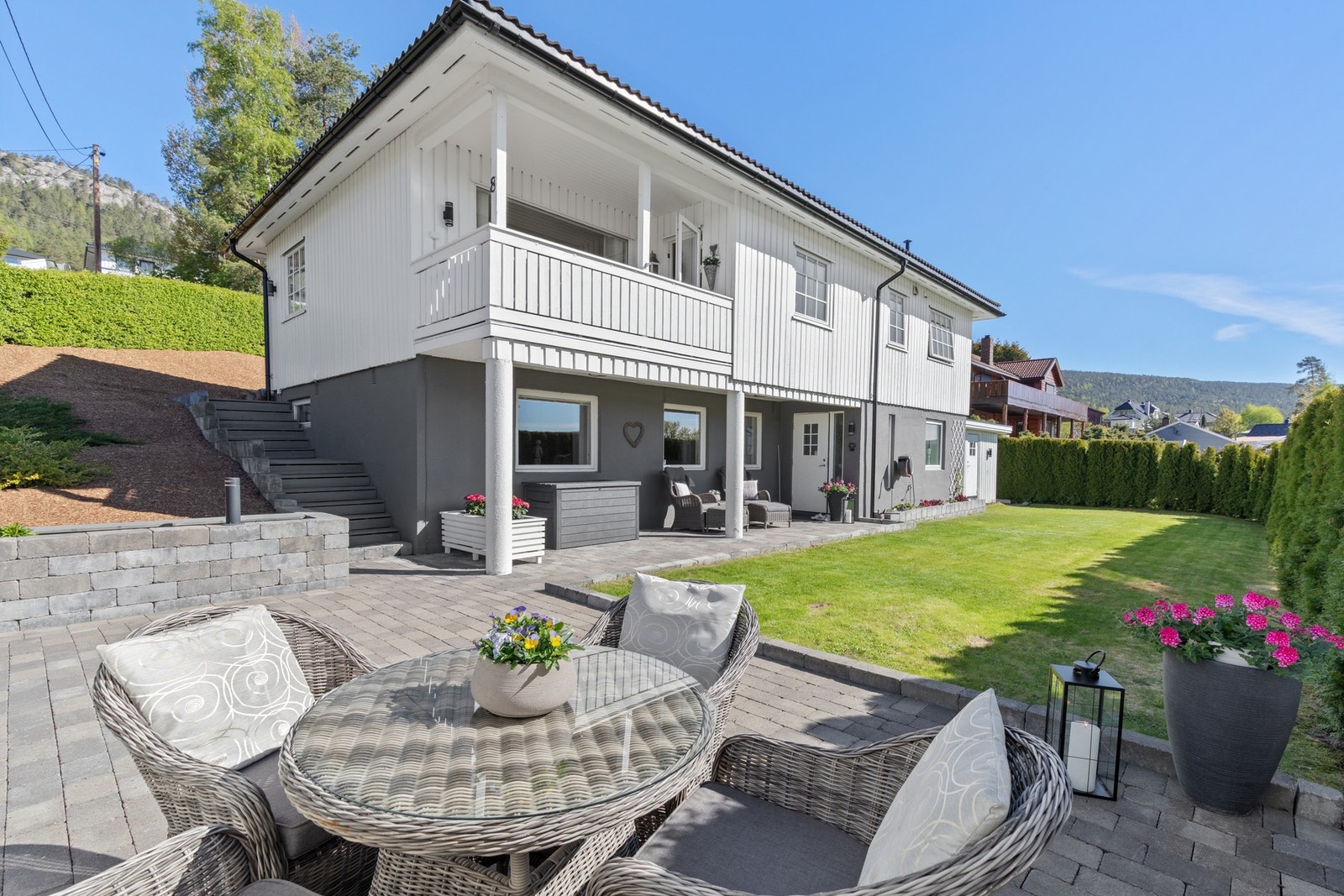 Boligen står på en solrik tomt med pent opparbeidet gressplen. Galleribilde