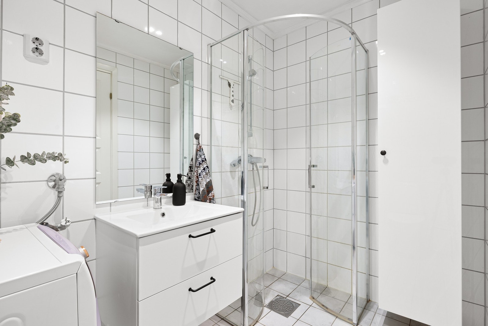 Badet er utstyrt med kran/avløp for vaskemaskin, samt innfellbare dusjdører i glass. Servantinnredningen er fra 2024. Galleribilde