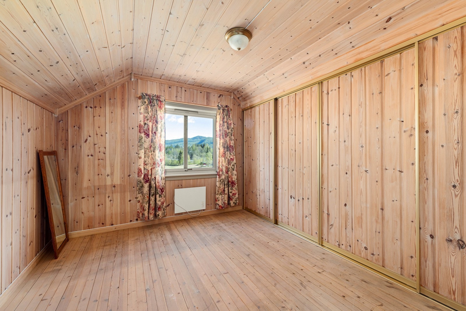 Det ene soverommet i andre etasje har rikelig med oppbevaringsplass i en stor skyvedørsgarderobe. Galleribilde