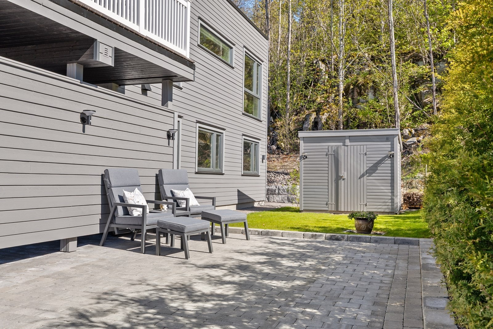 Frittstående utebod med god plass til lagring, ekstra parkeringsplass og skjermet uteplass. Galleribilde