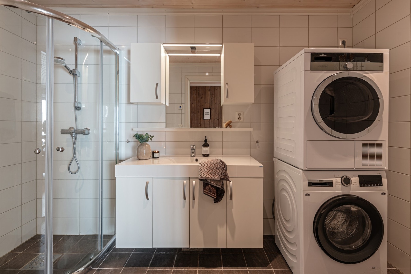 Badet er utstyrt med servantinnredning, håndvask, toalett og dusj med skyvedører. Opplegg for vaskemaskin. Galleribilde