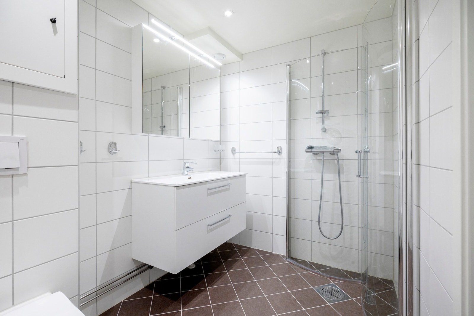 Badet er utstyrt med dusjnisje, servant med innredning og vegghengt toalett Galleribilde