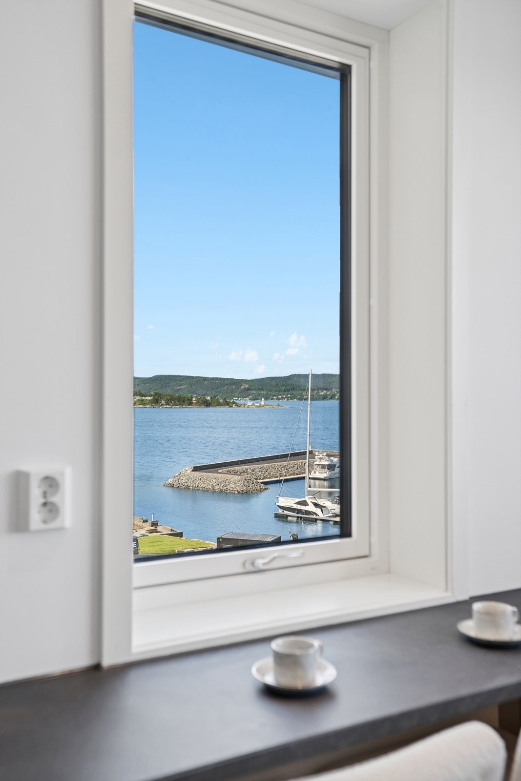 Ved bardisken kan du nyte morgenkaffen sammen med utsikten til havna og båtlivet. Galleribilde