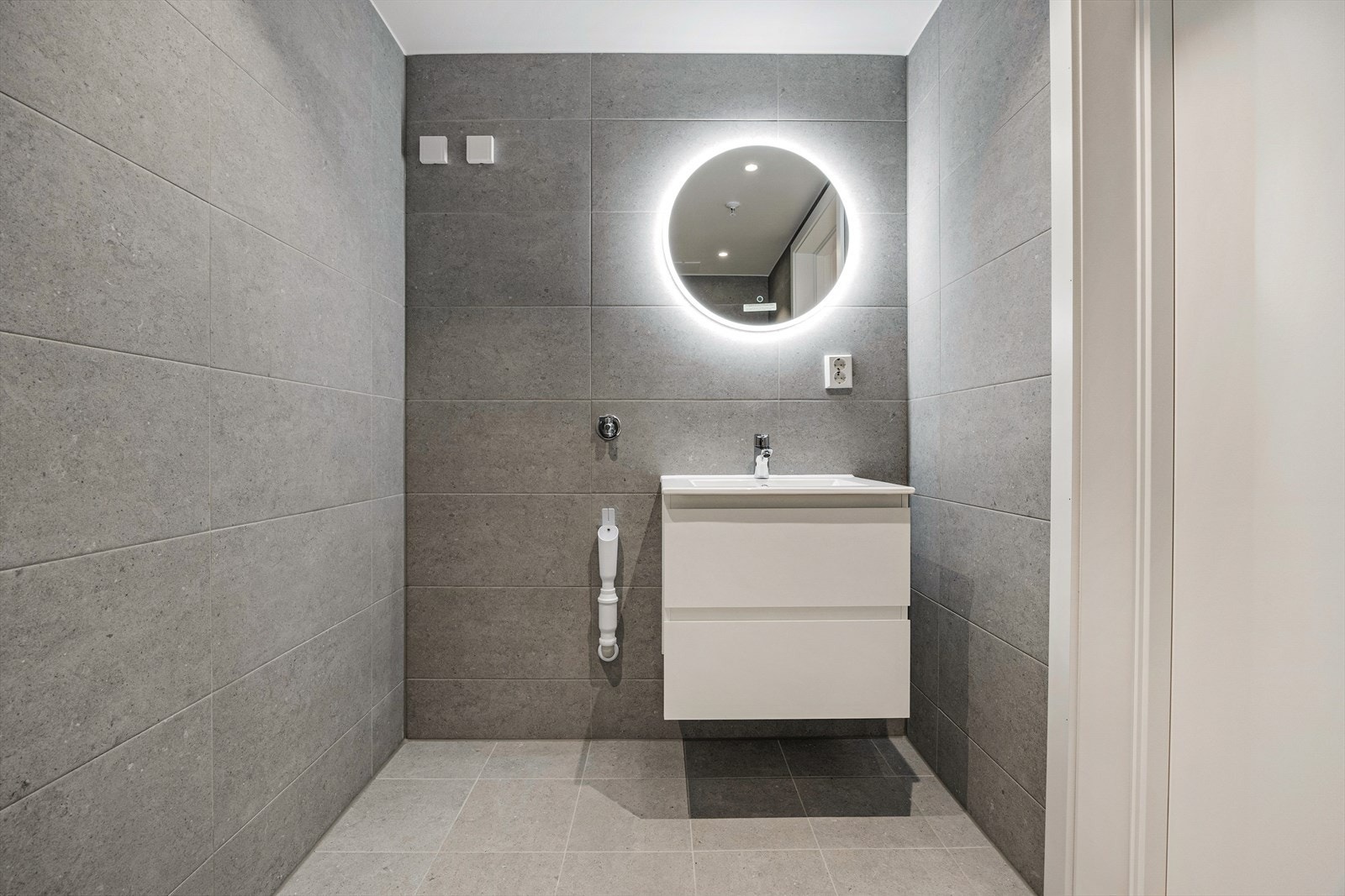 Badet er helfliset med en moderne servantinnredning og et stort speil med belysning. Galleribilde