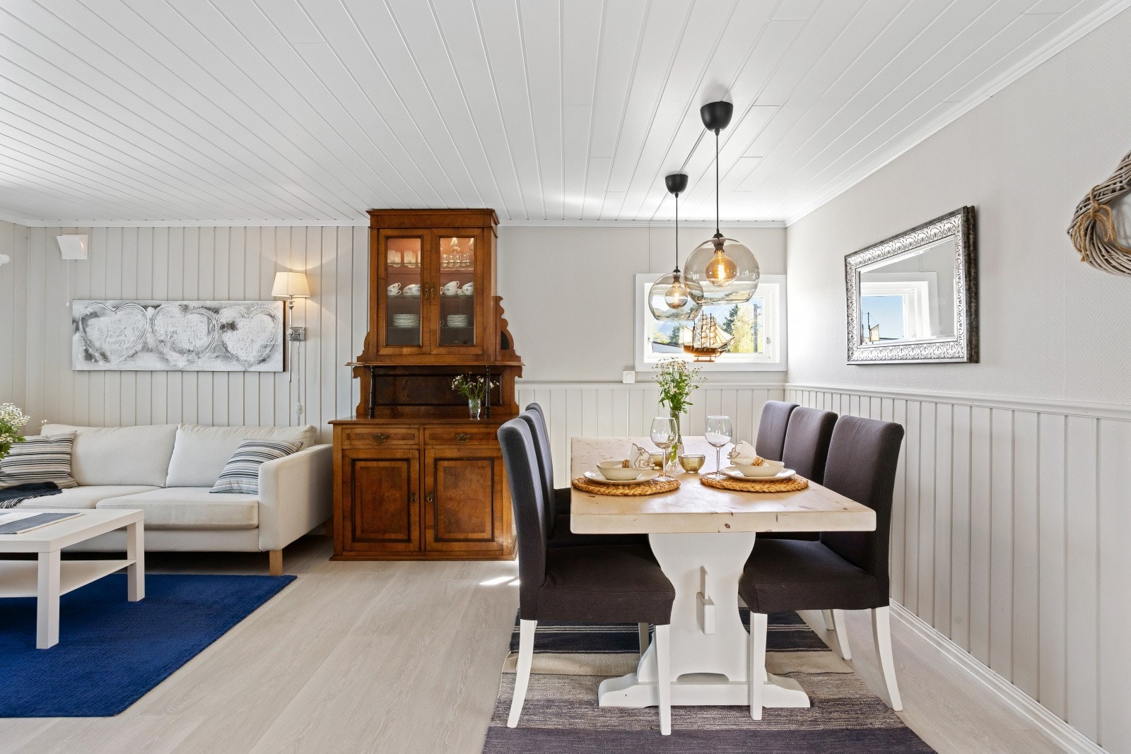 Lyse og trivelige oppholdsrom med panel som er malt i tidsriktige farger. Galleribilde