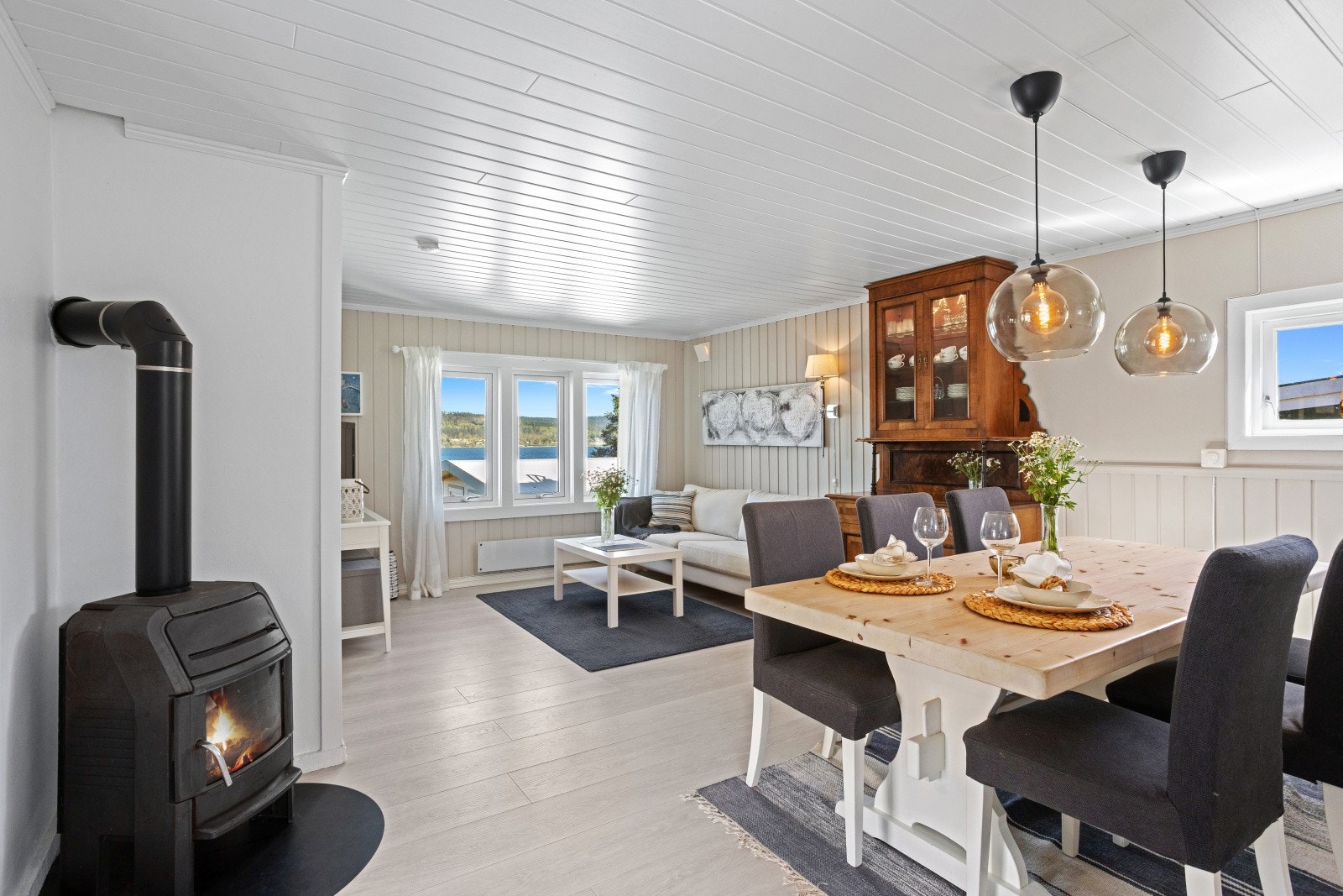Stuen har plass til både sofagruppe og spisebord. Peisovnen gir god varme og stemning. Galleribilde