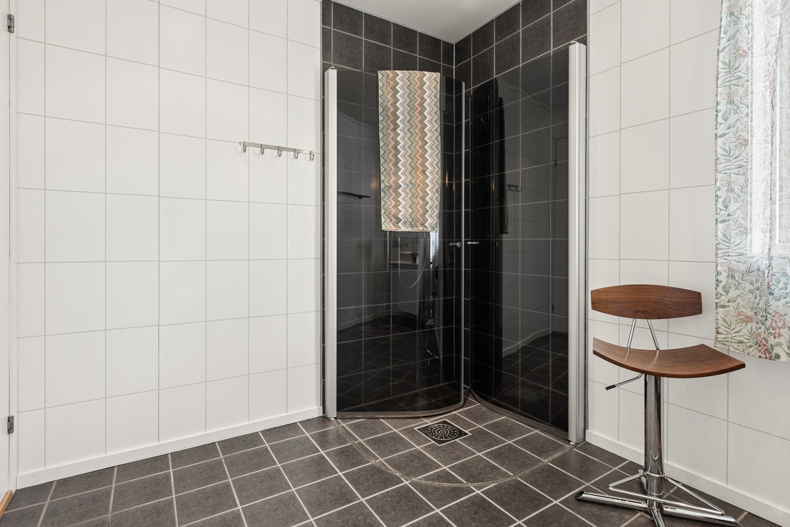 Badet er blant annet utstyrt med hjørnedusj med innfellbare dusjdører, vegghengt toalett, varme i gulv og vegghengt servant. Galleribilde