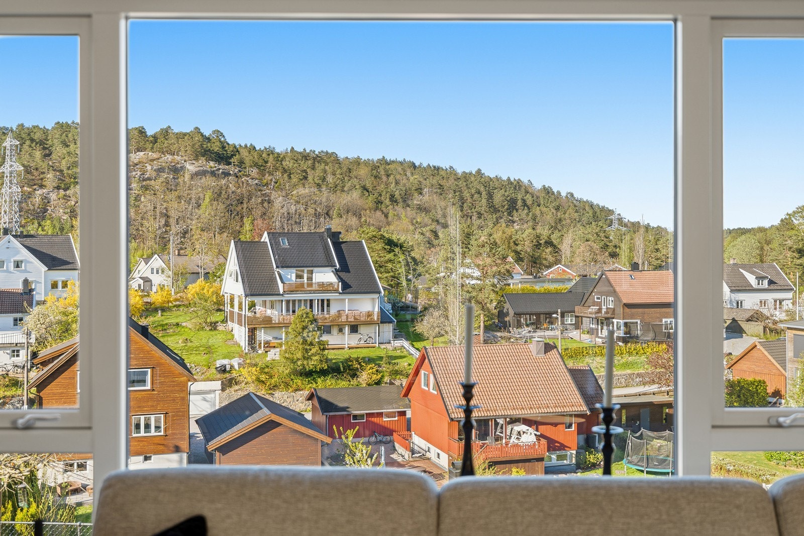 Flott utsikt fra stuevindu mot skog og omkringliggende bebyggelse Galleribilde