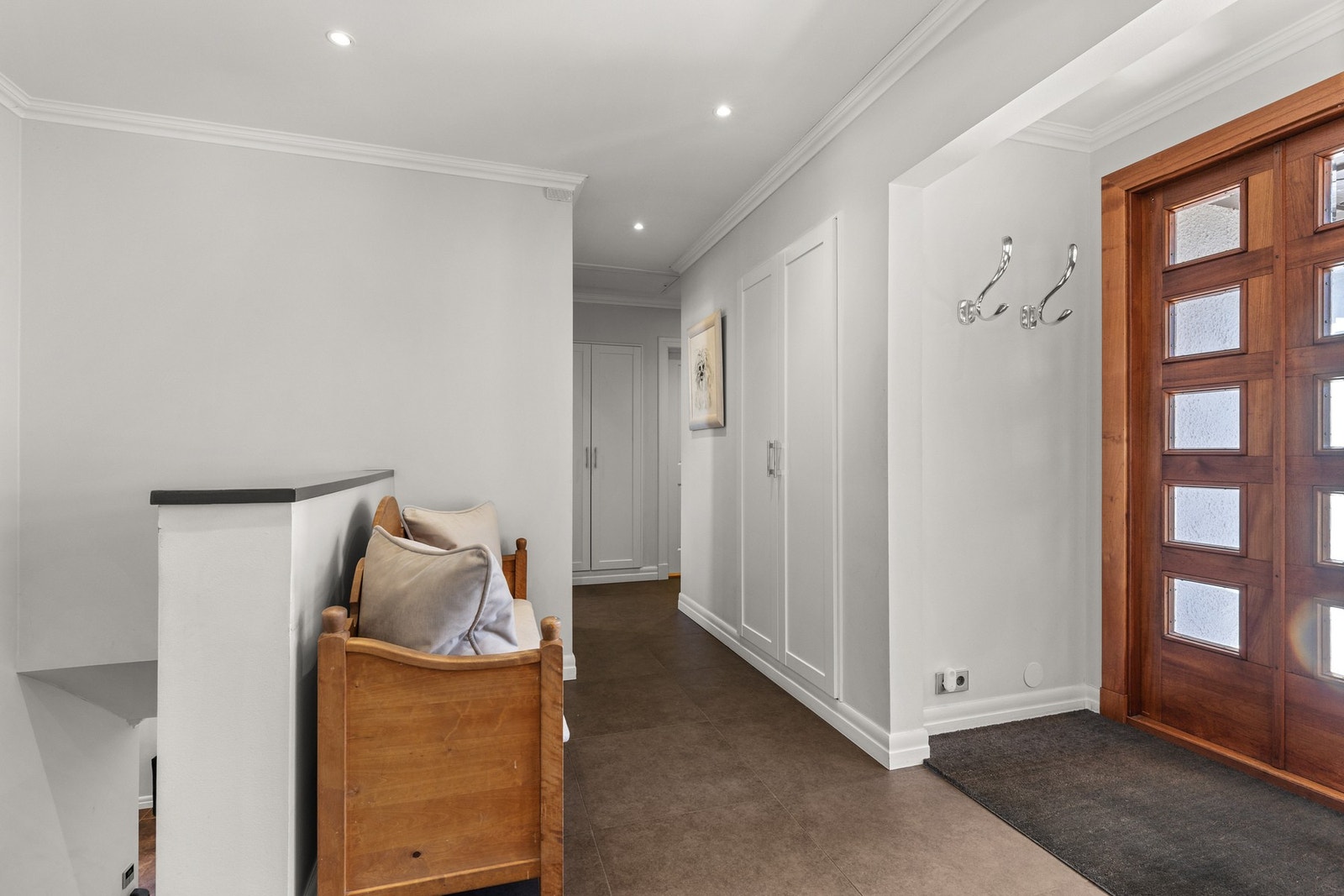Entréen er lys og romslig, med flislagt gulv, malte overflater og innfelte downlights i himling. Galleribilde