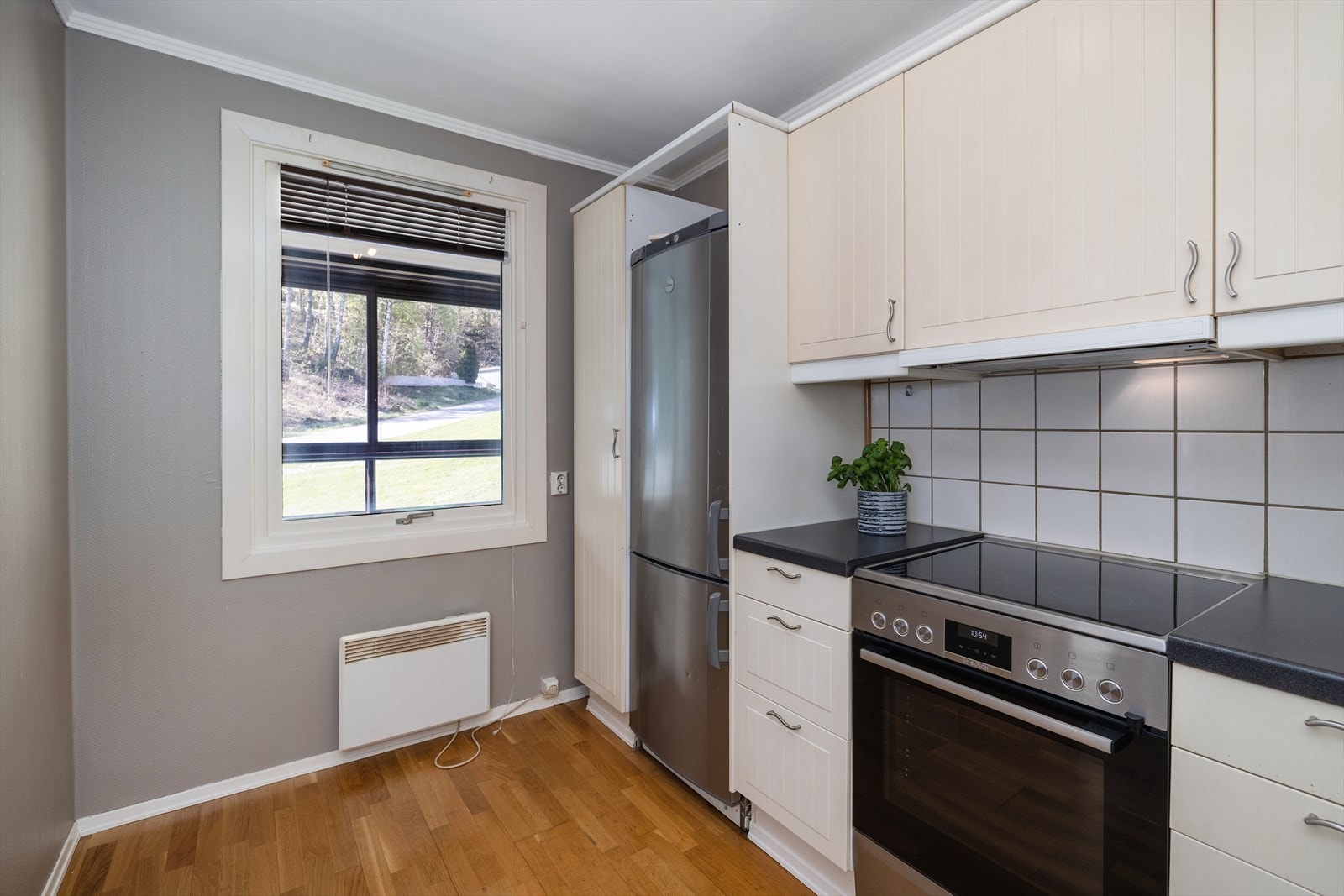 Kjøkkeninnredning med profilerte fronter og laminat benkeplate, plass til spisebord ved vindu. Galleribilde