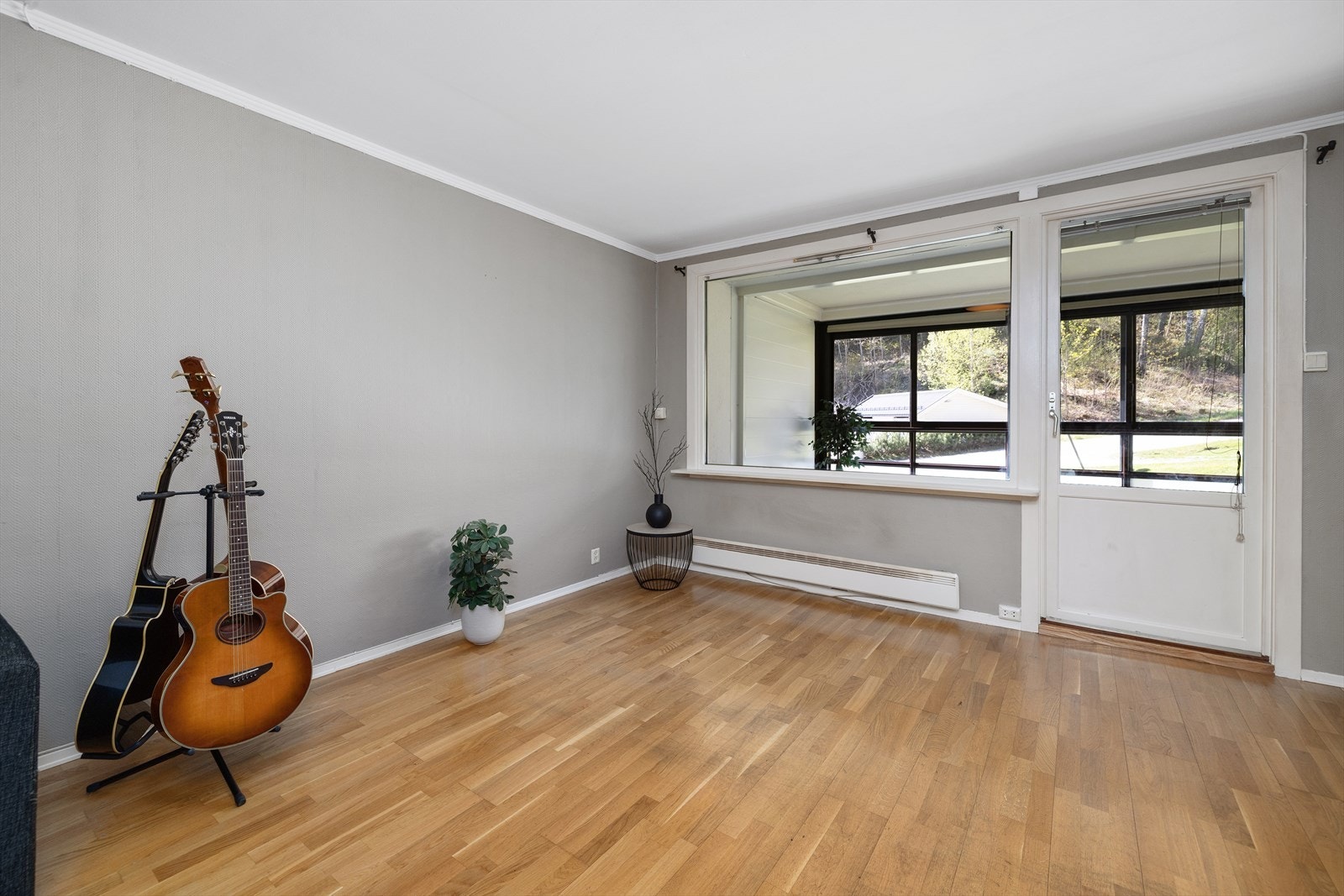 En terrassedør med 2-lags isolerglass fra 1999 kobler stuen direkte til den innglassede balkongen. Galleribilde