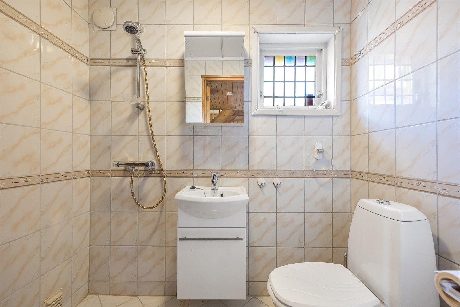 Badet i underetasjen er innredet med servant med underskap, gulvstående toalett, dusj på gulv og speilskap. Galleribilde